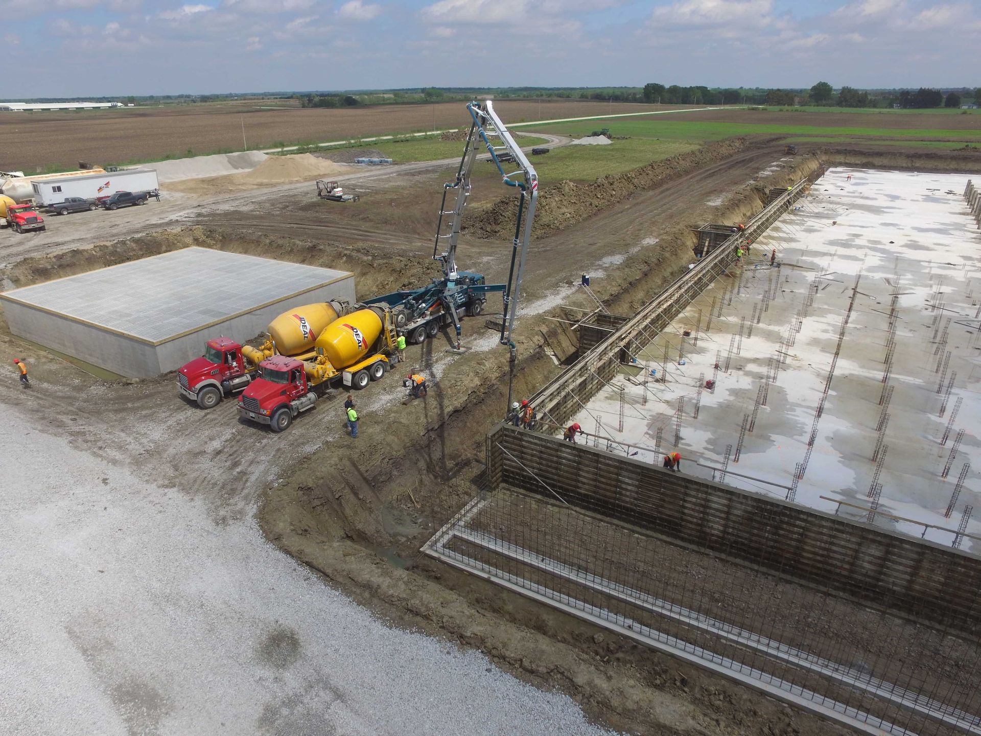 An aerial view of a construction site with trucks and a crane.