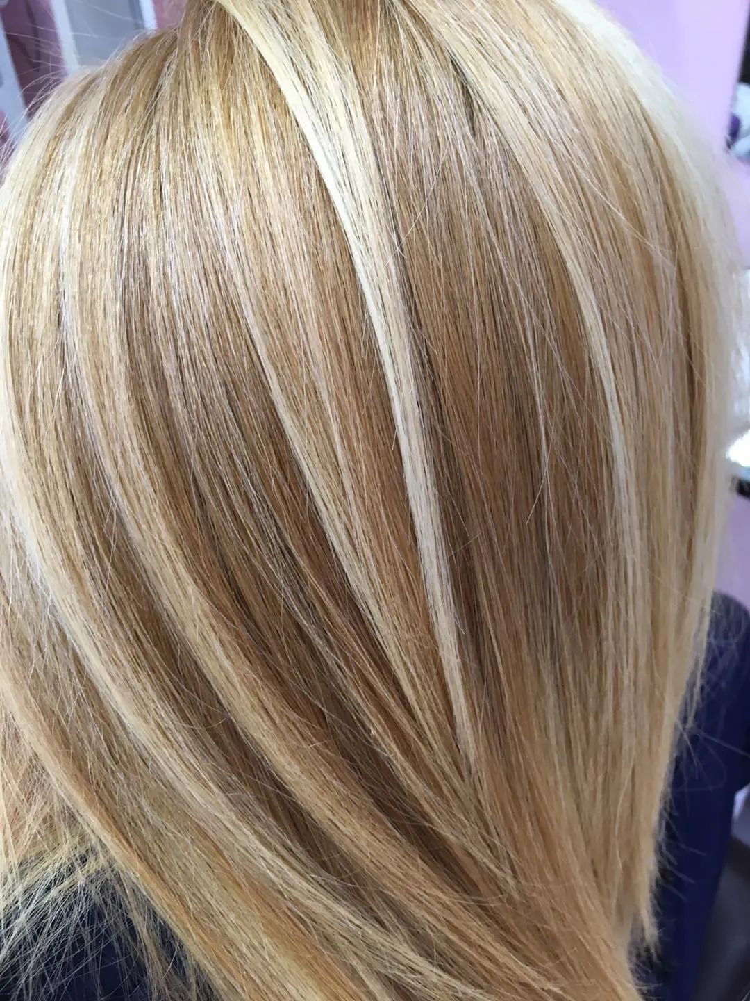 Un primo piano dei capelli biondi di una donna in un salone.