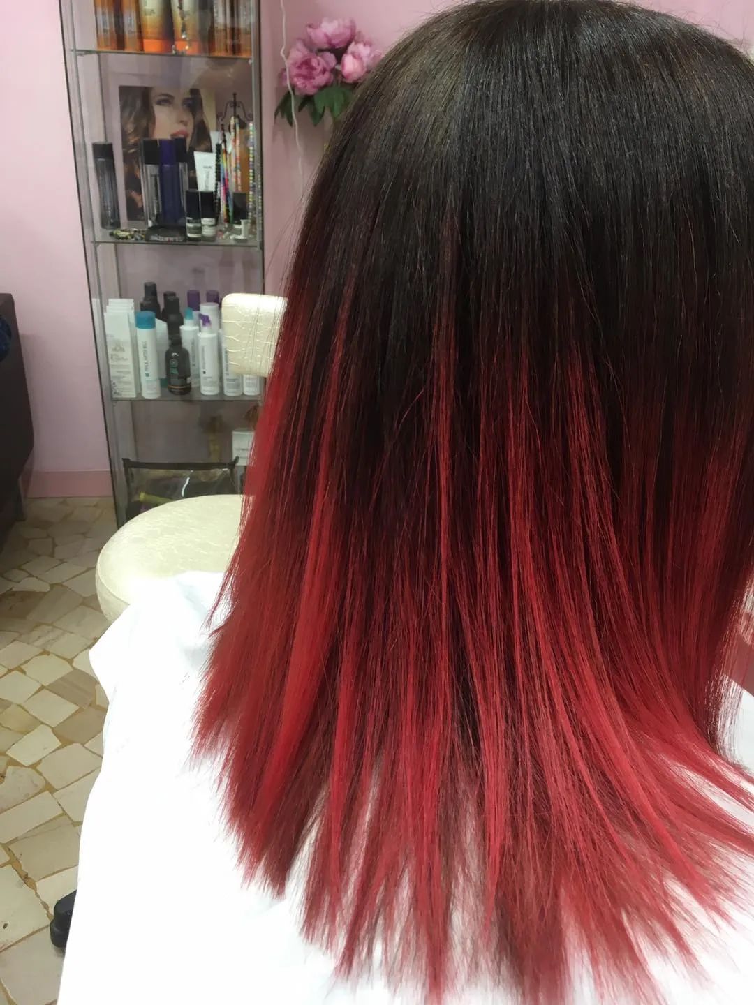 Una donna con i capelli rossi è seduta su una sedia in un salone.