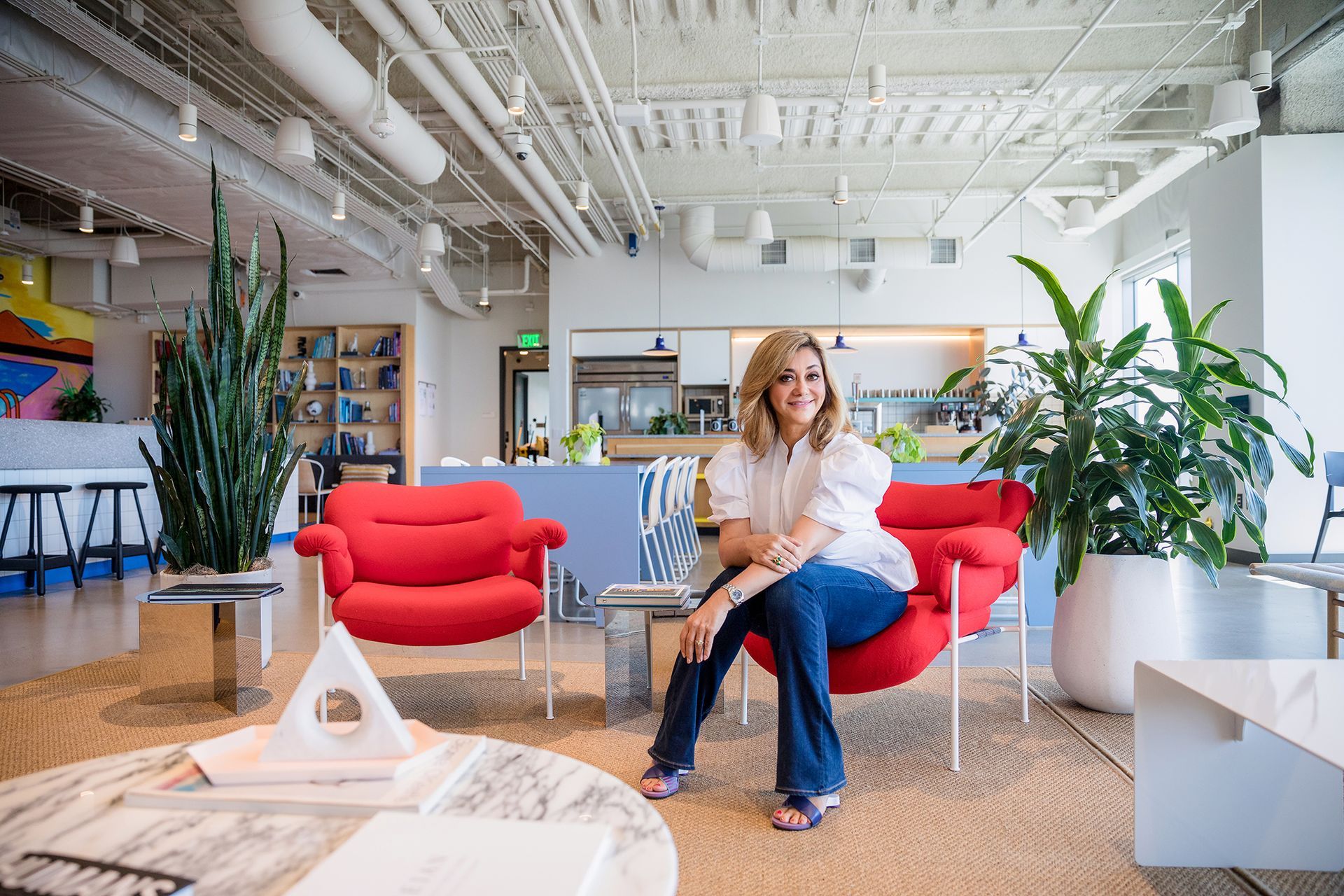A woman is sitting in a red chair in a living room.