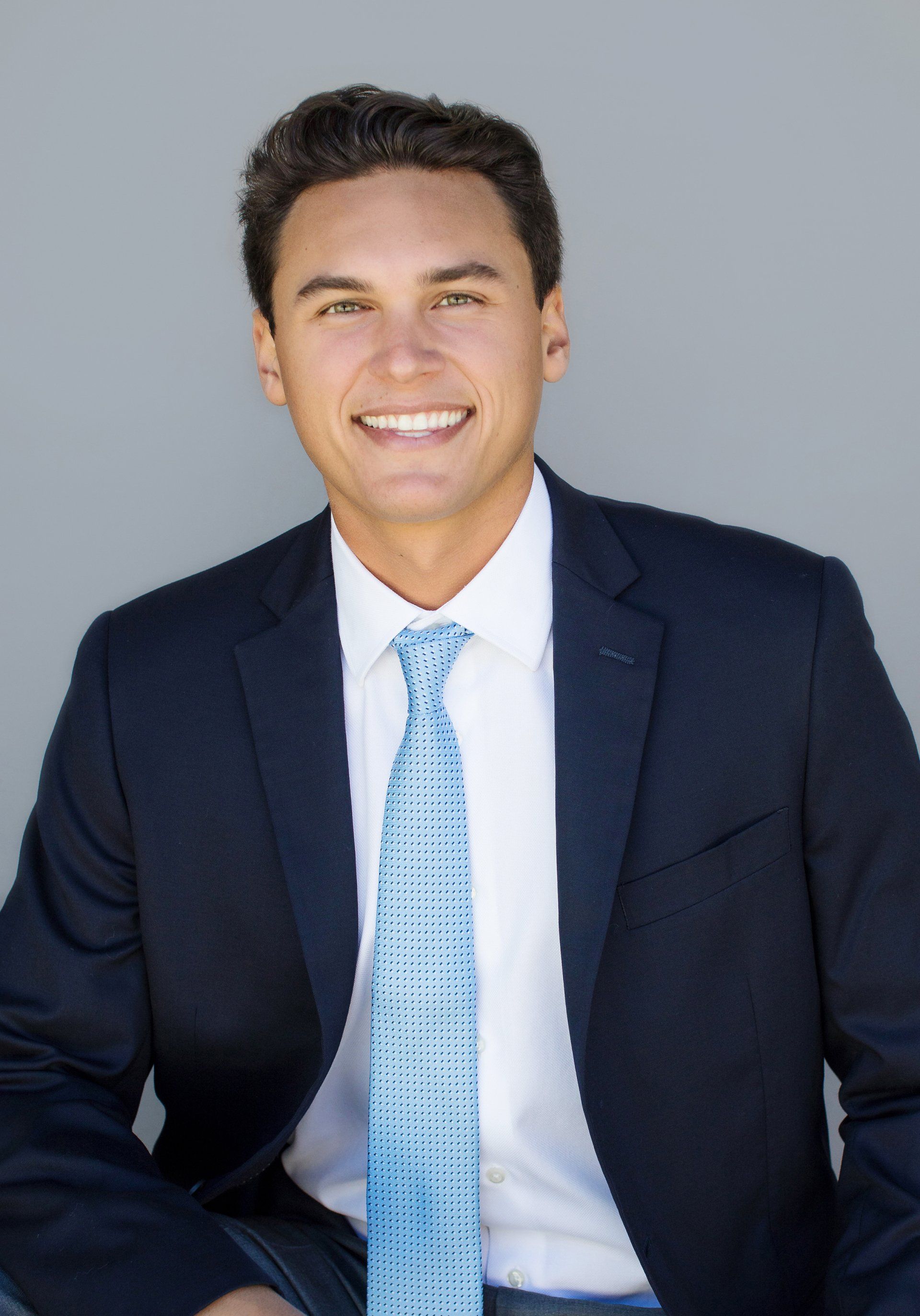 A man in a suit and tie is smiling for the camera.