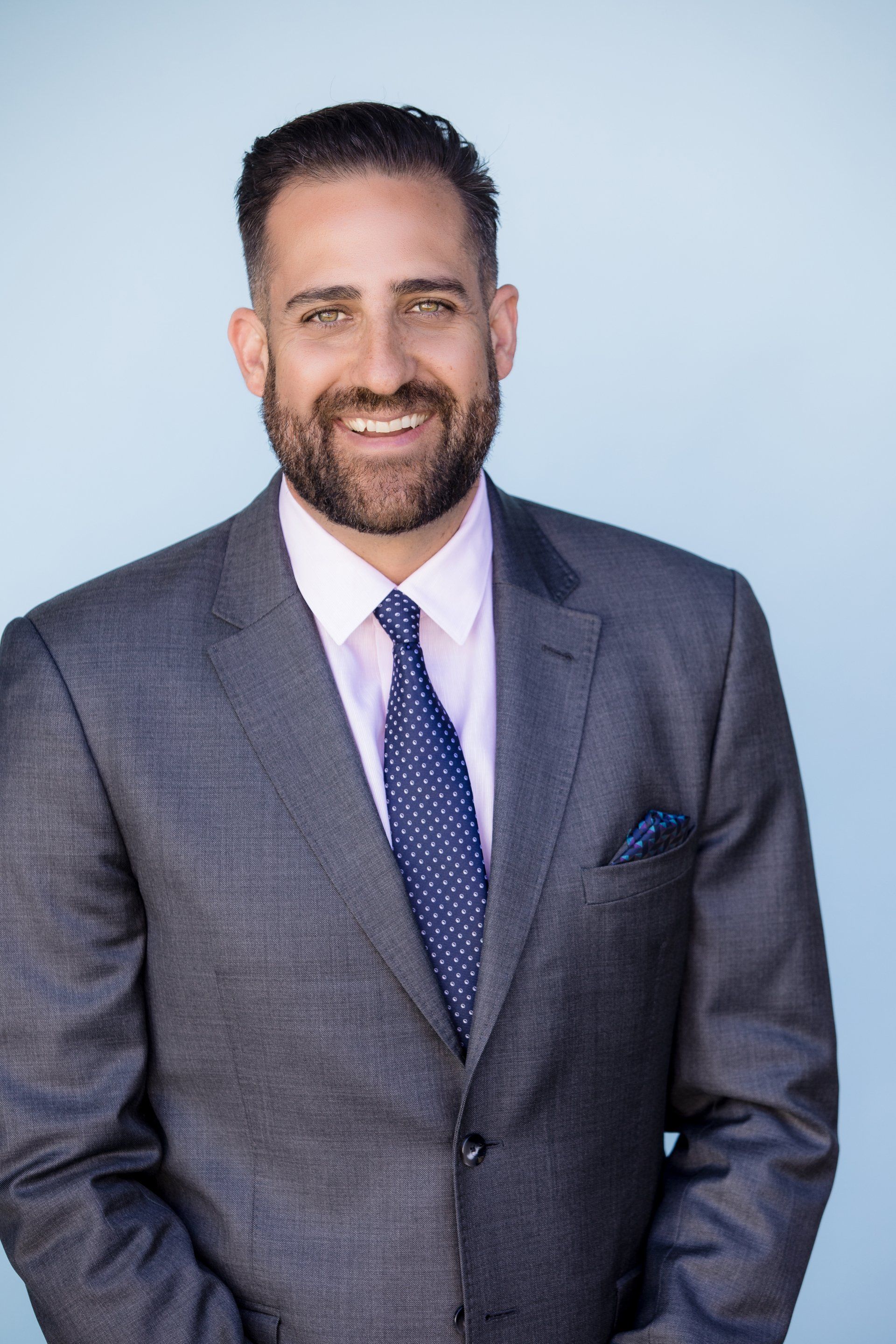 A man in a suit and tie is smiling for the camera.