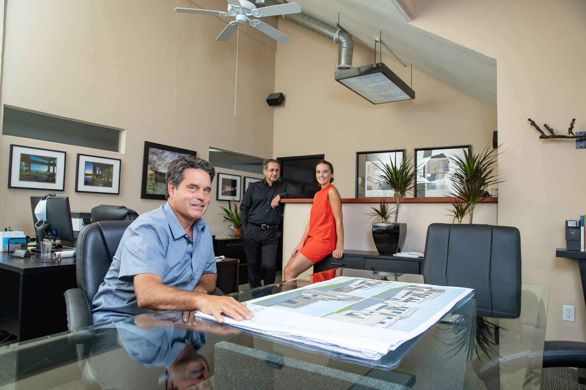 A man and a woman are sitting at a table in an office.