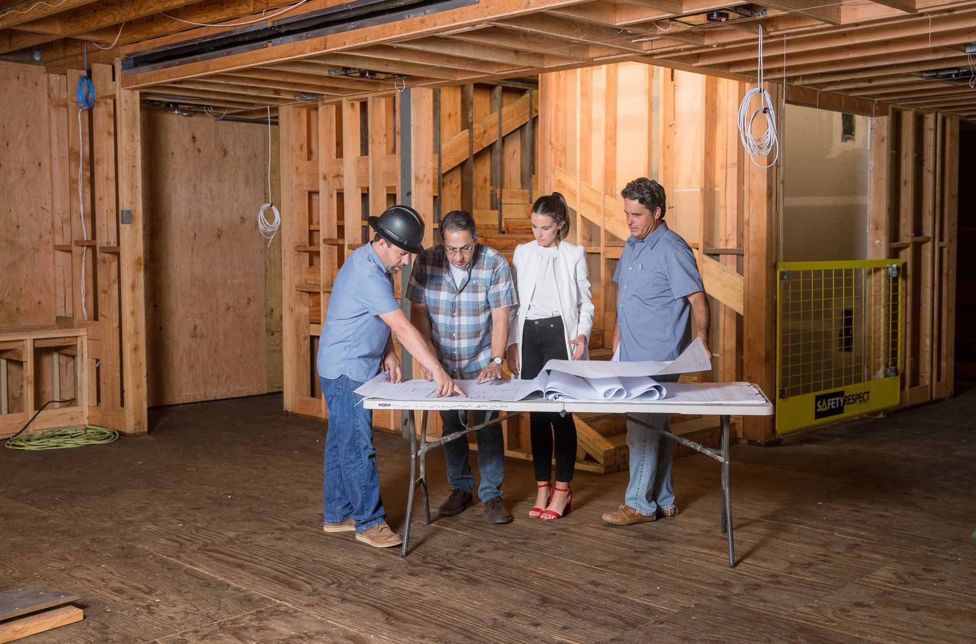 A group of people are standing around a table in a building under construction.