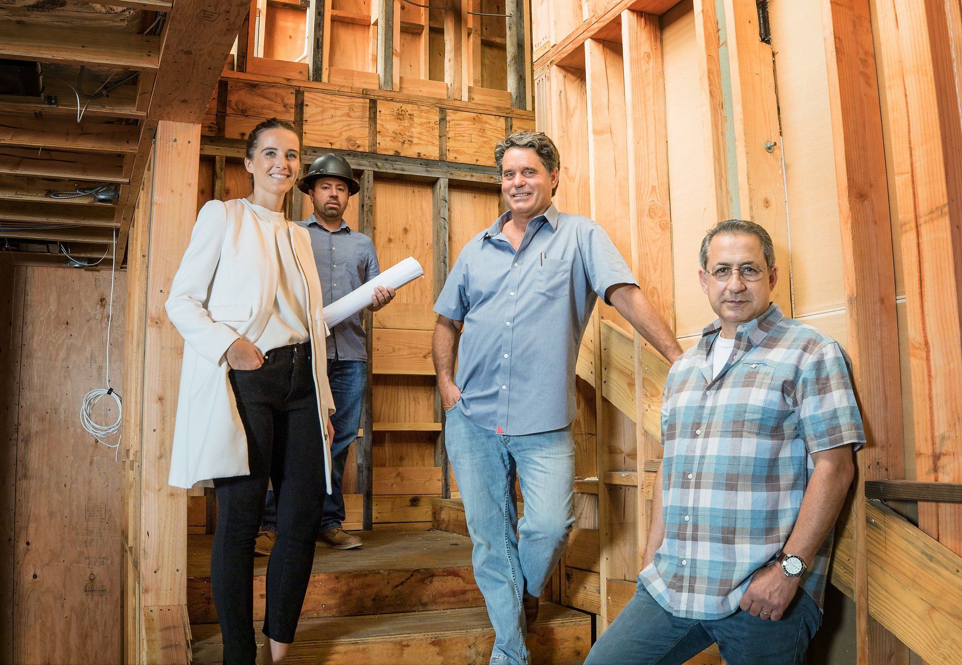 A group of people are standing next to each other in a building under construction.
