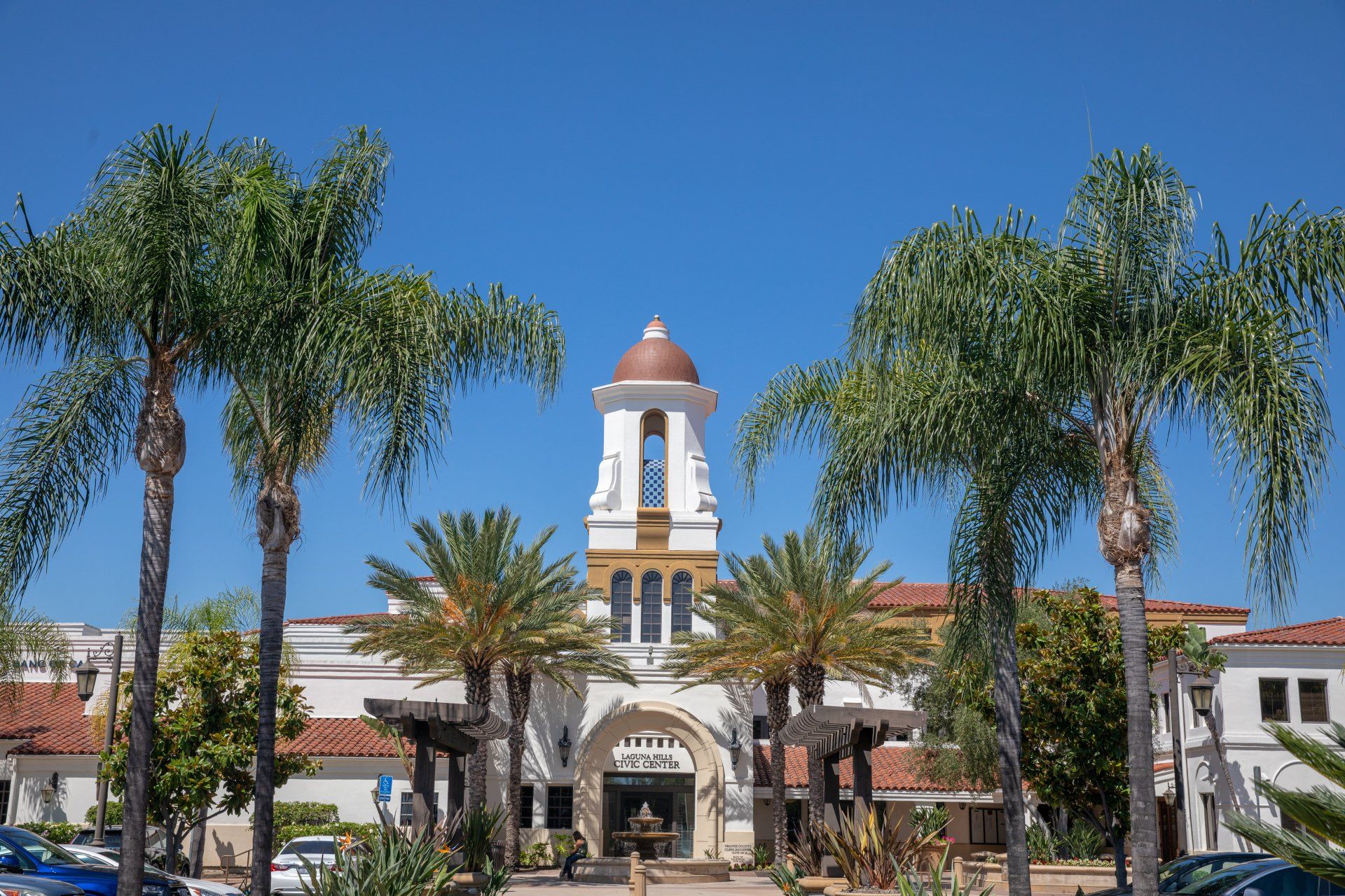 A hotel with palm trees in front of it on a sunny day.