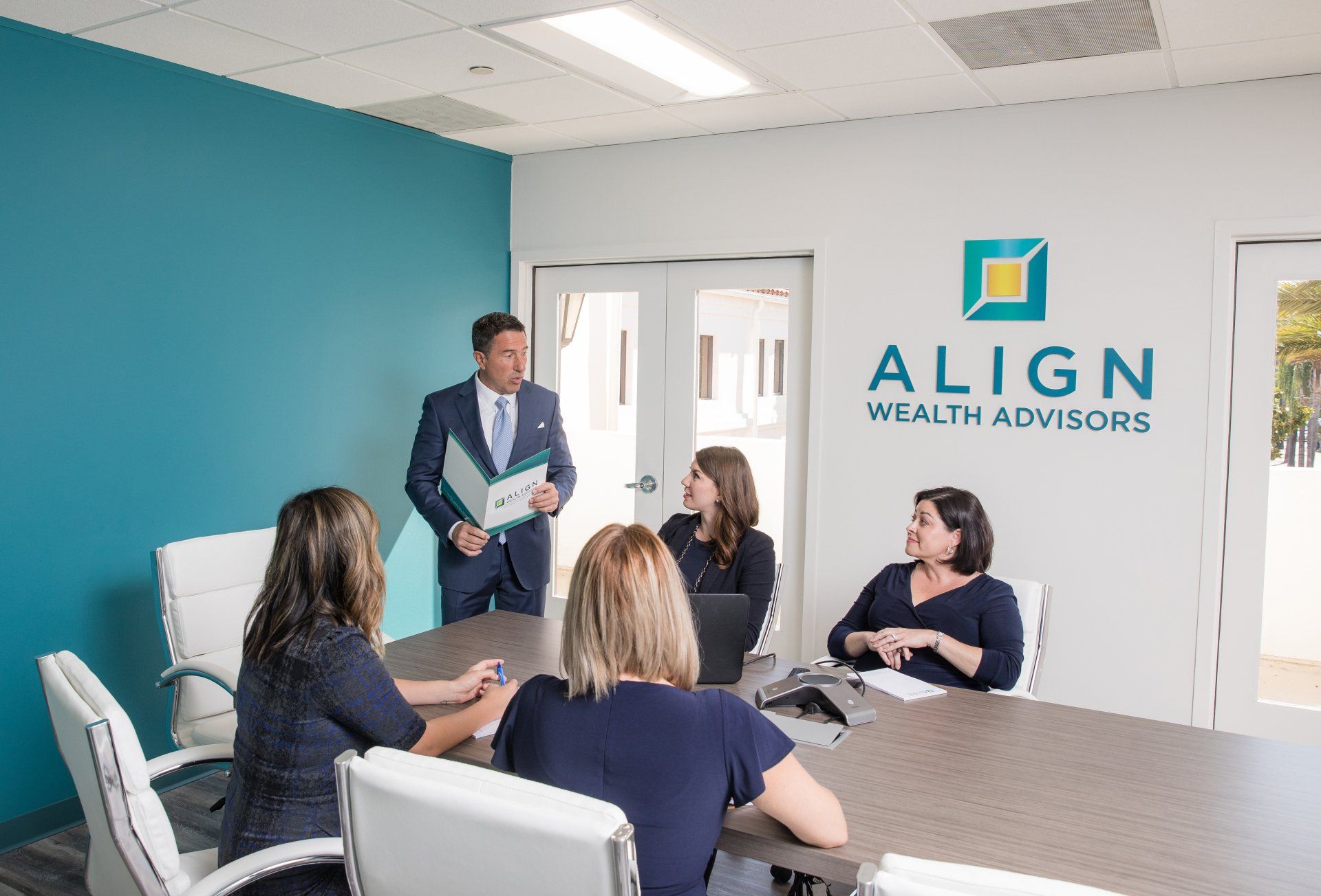 A group of people are sitting around a table in a conference room.