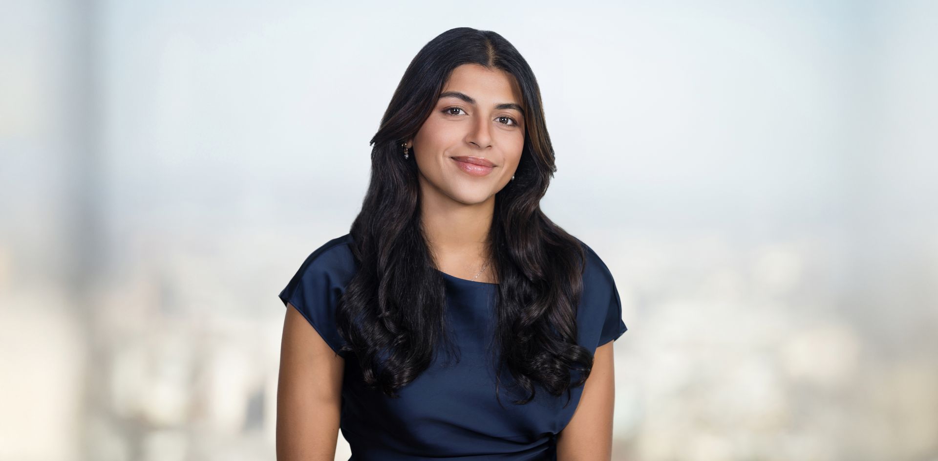 The woman is wearing a blue dress and smiling for the camera.