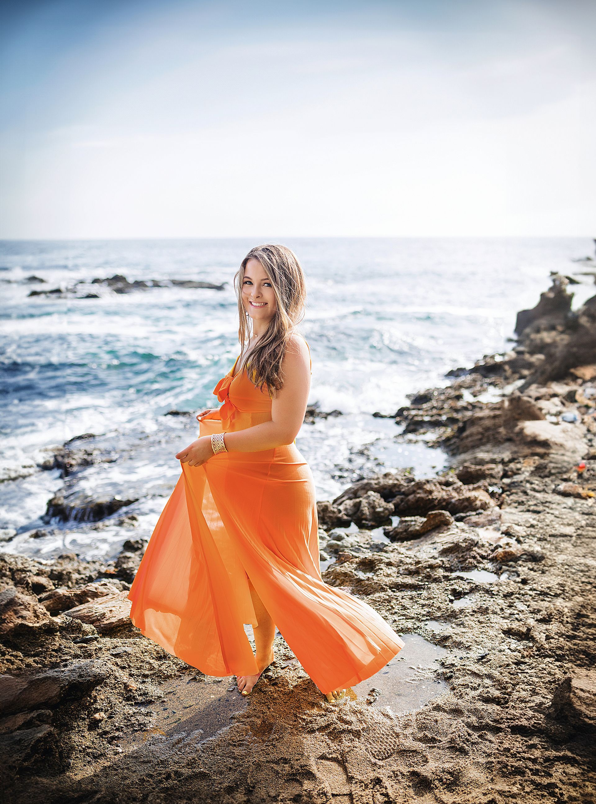 Victoria beach senior session with a throw the dress pose in front of the ocean.
