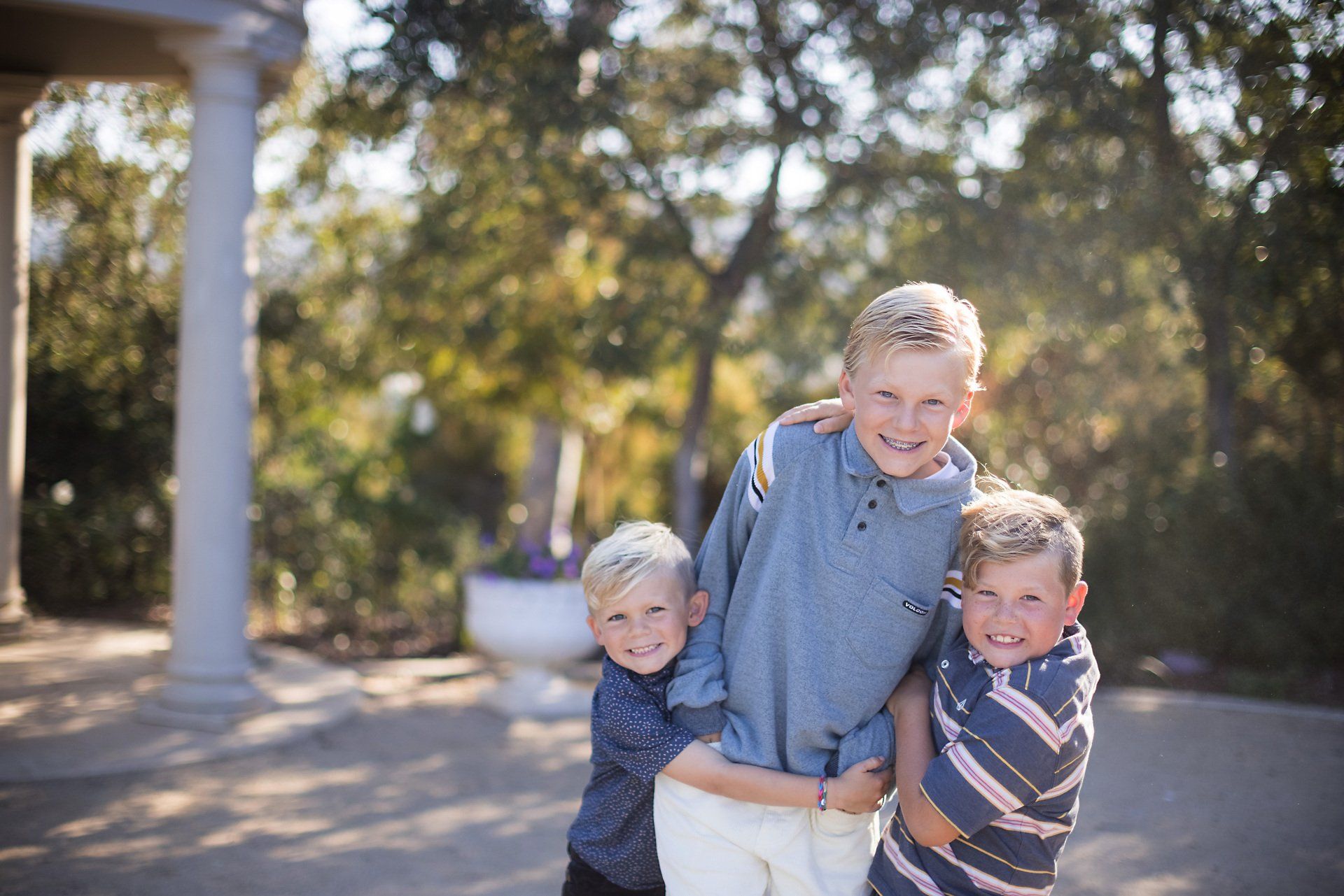 Boy at a family photography session in Laguna Niguel Botanical Gardens  giving each other a big hug.