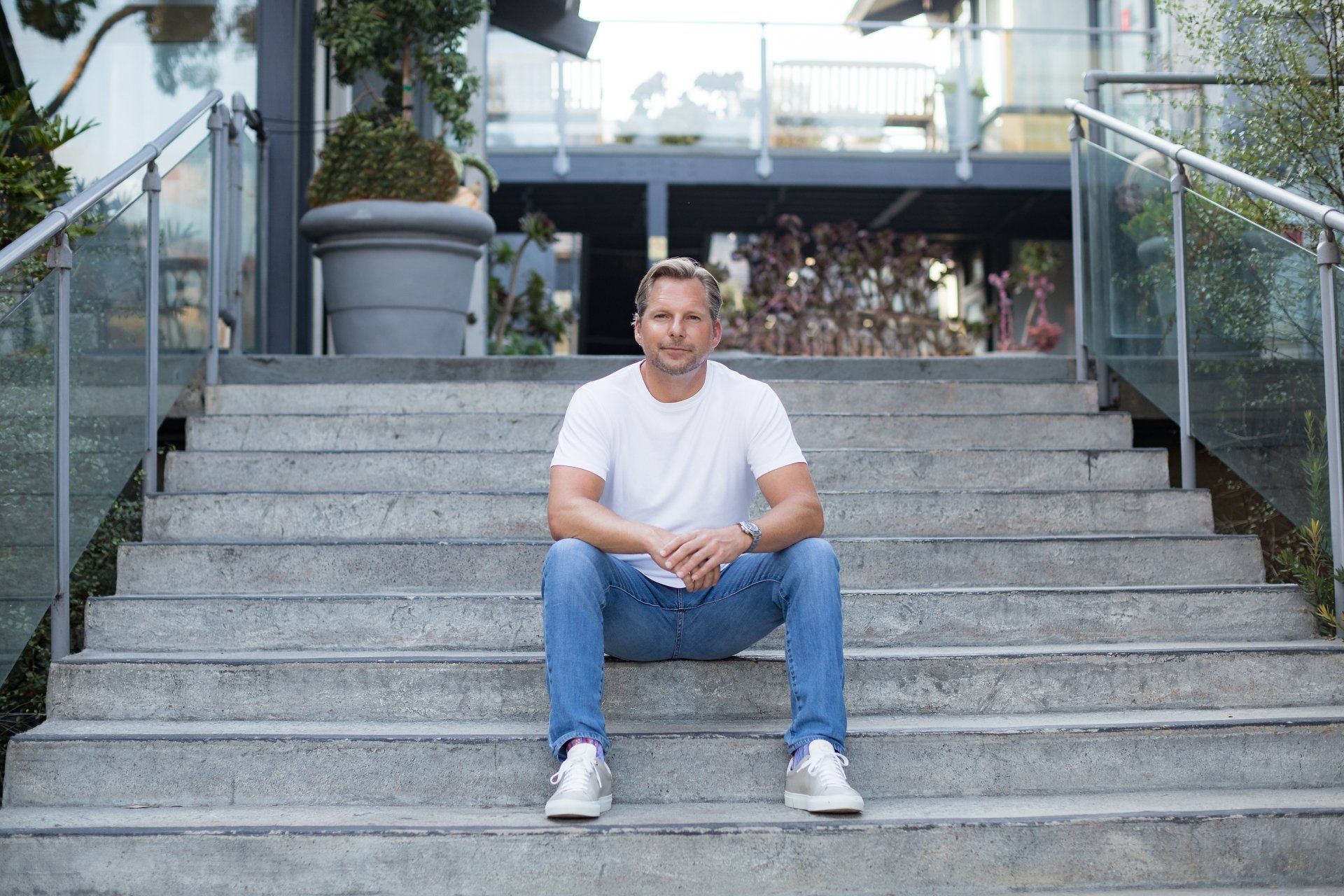 A man is sitting on the steps of a building.