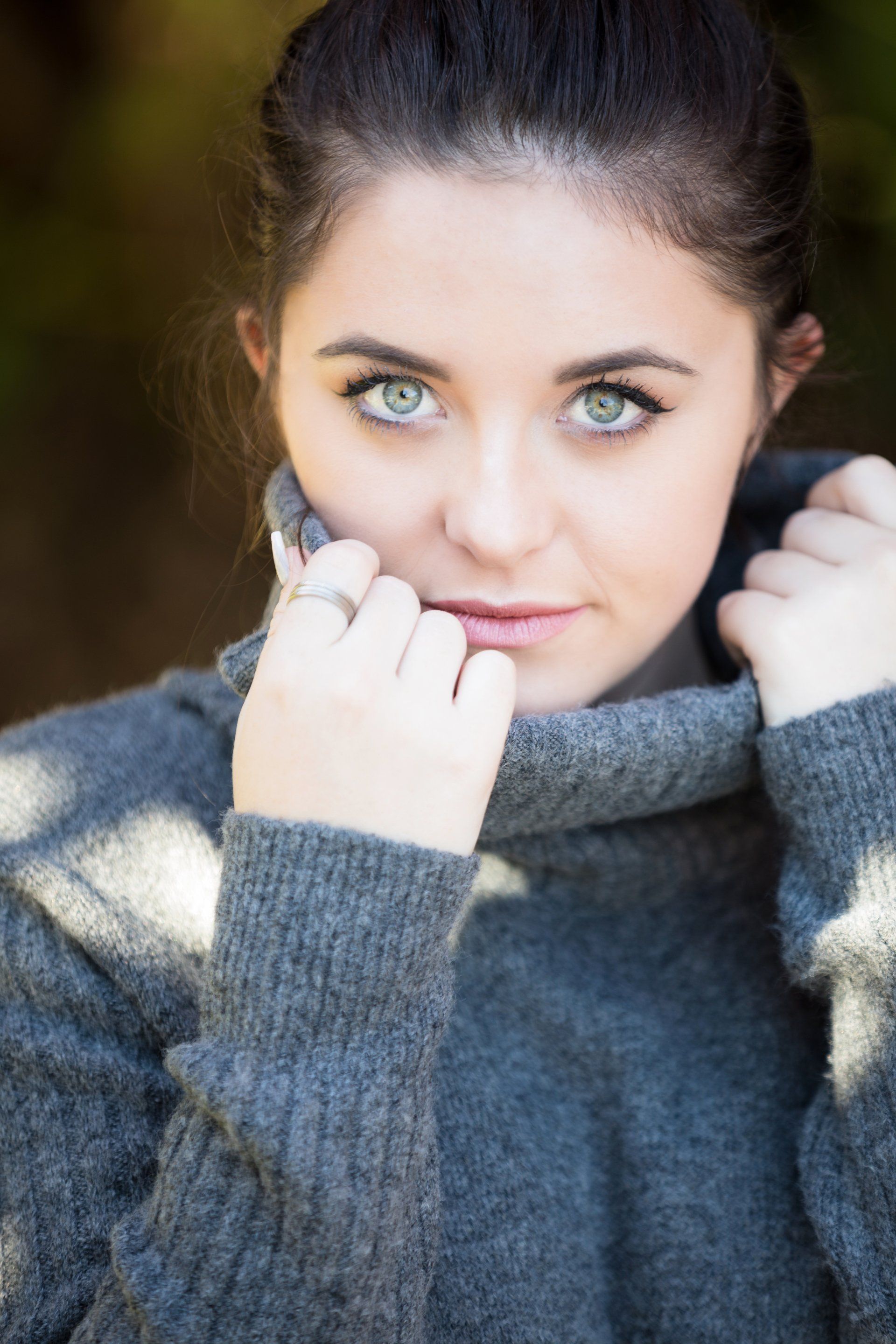 A close up of a woman wearing a turtleneck sweater.