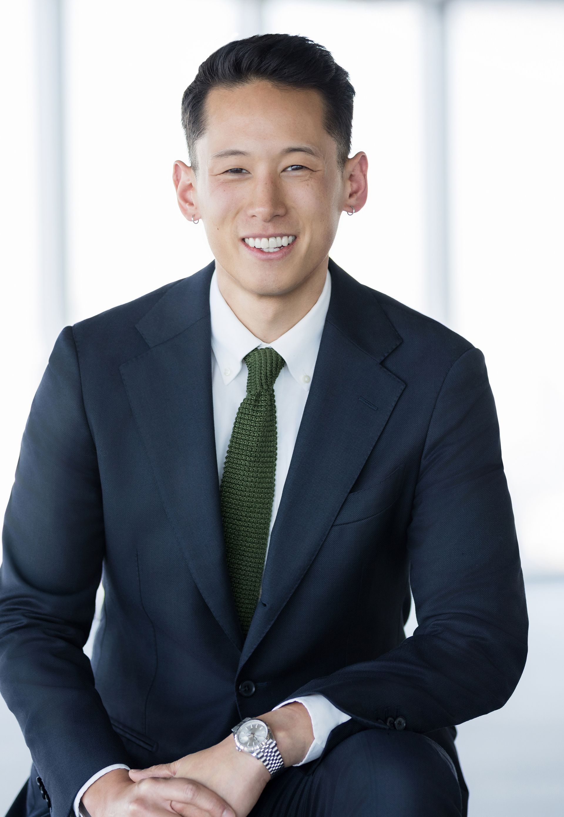 A man in a suit and tie is smiling for the camera