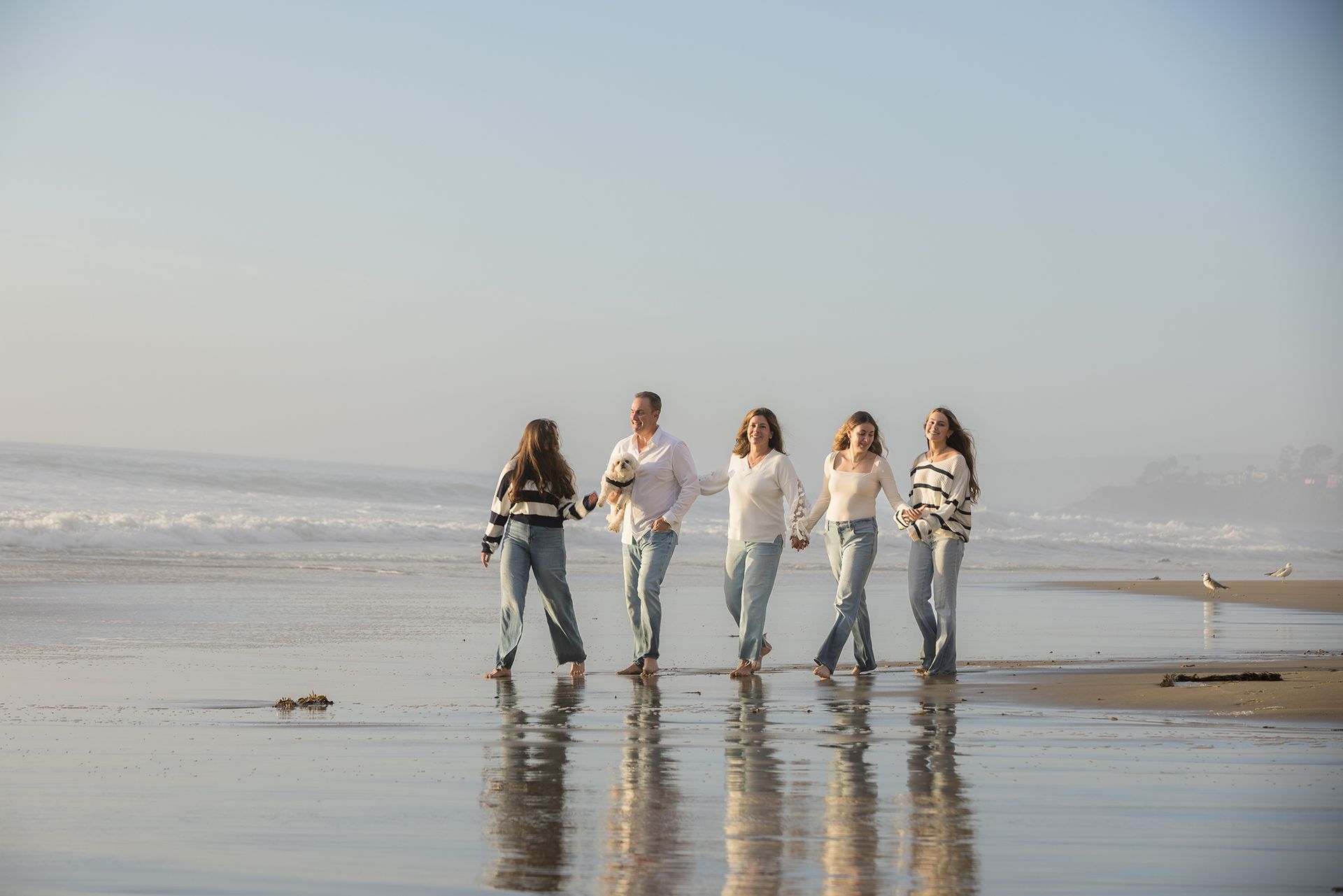 Family walking along Strands beach in Dana Point at Sunset