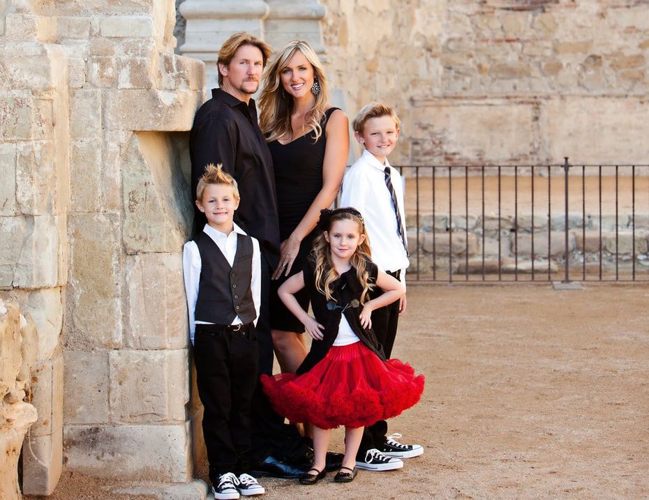 A family posing for a picture in front of a stone wall