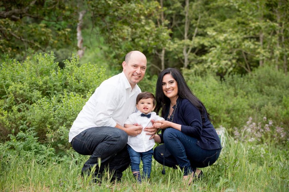 A family is posing for a picture in the grass.