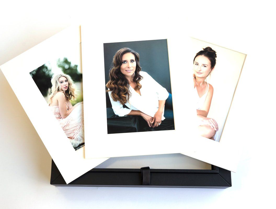 Three pictures of women are sitting on top of a black box.