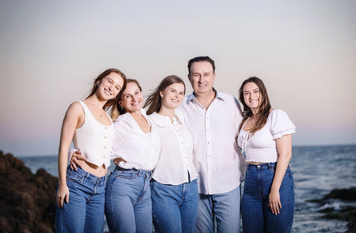 Laguna Beach Family portrait session at sunset with a family of 5 wearing white tops and jeans.