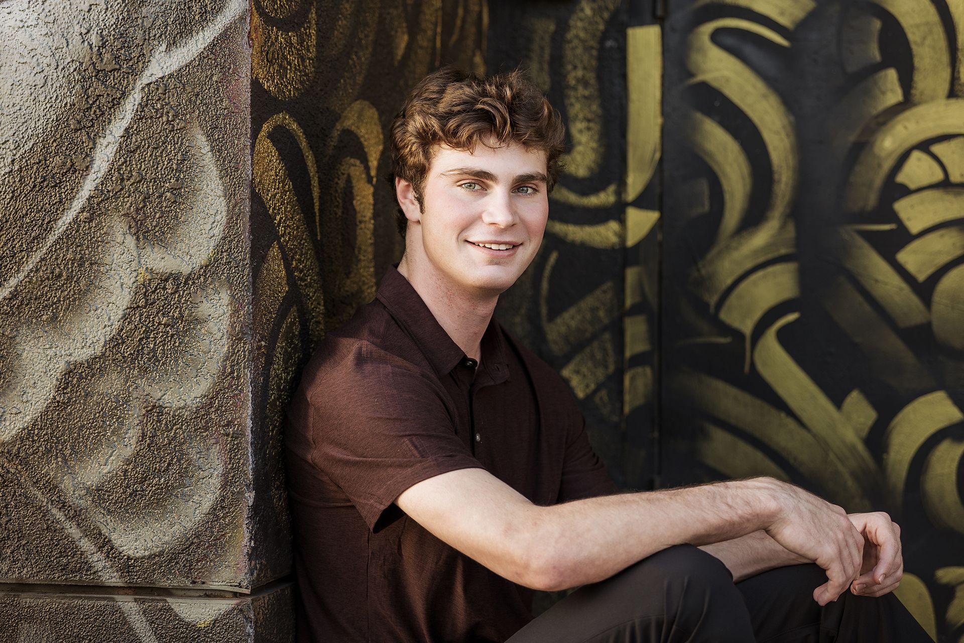 Younger brother sitting in a door way during a family portrait Santa Ana Art District.
