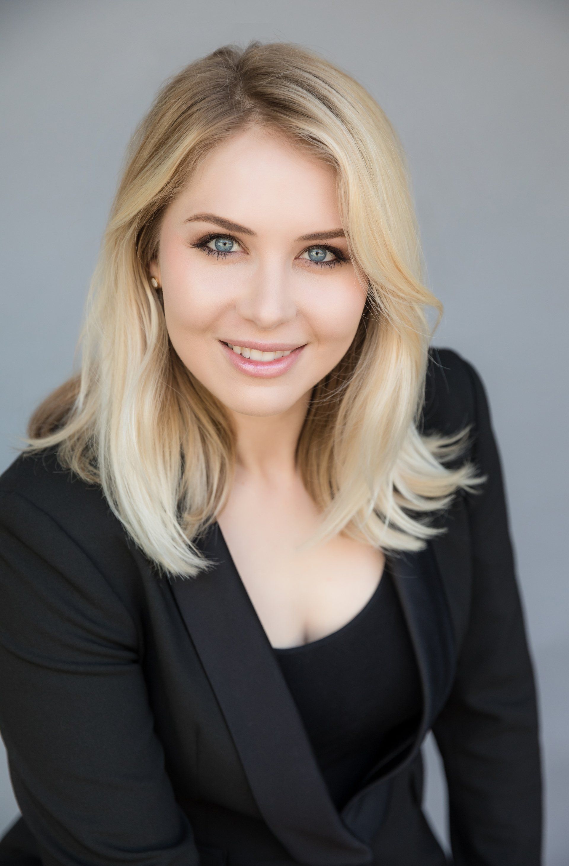 The woman is wearing a black jacket and smiling for the camera.
