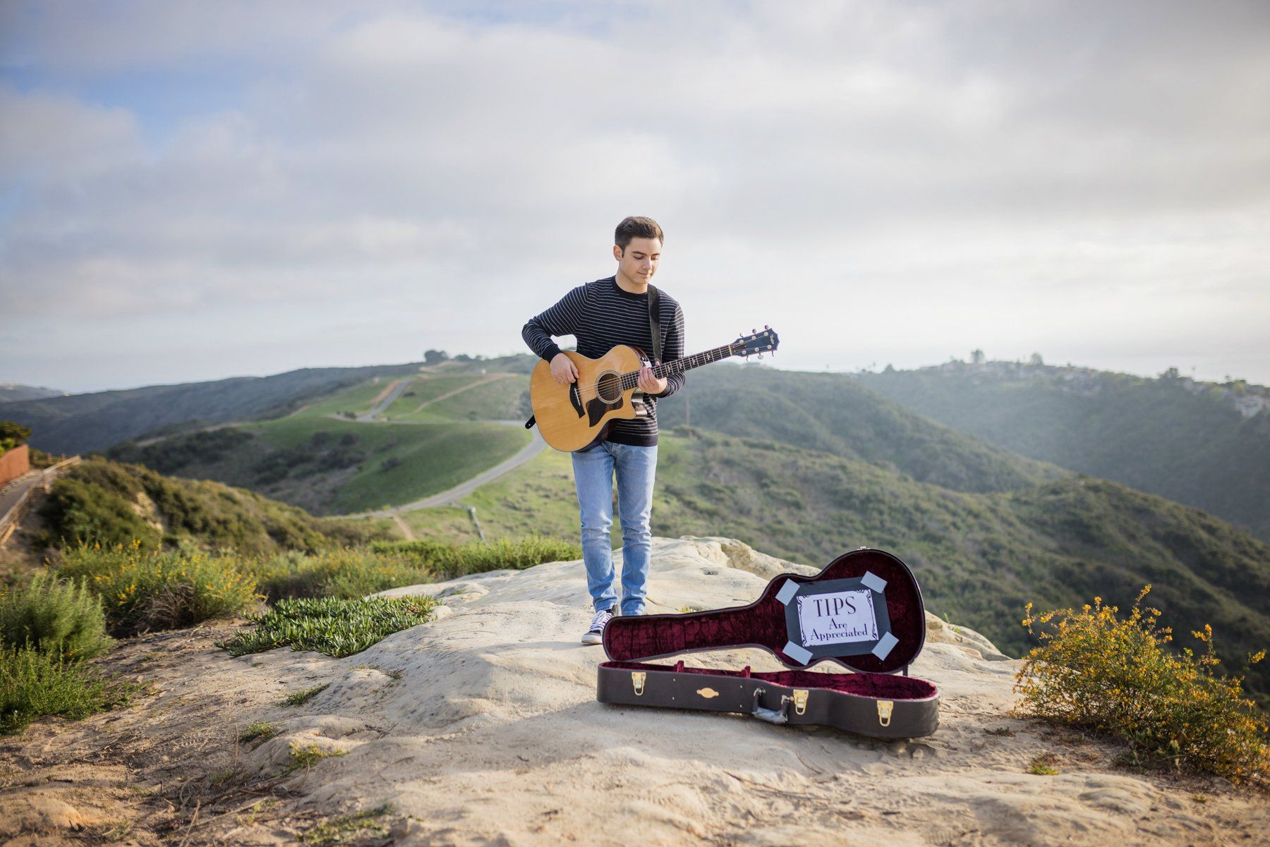 High school senior playing the guitar in Laguna Beach for his portrait session