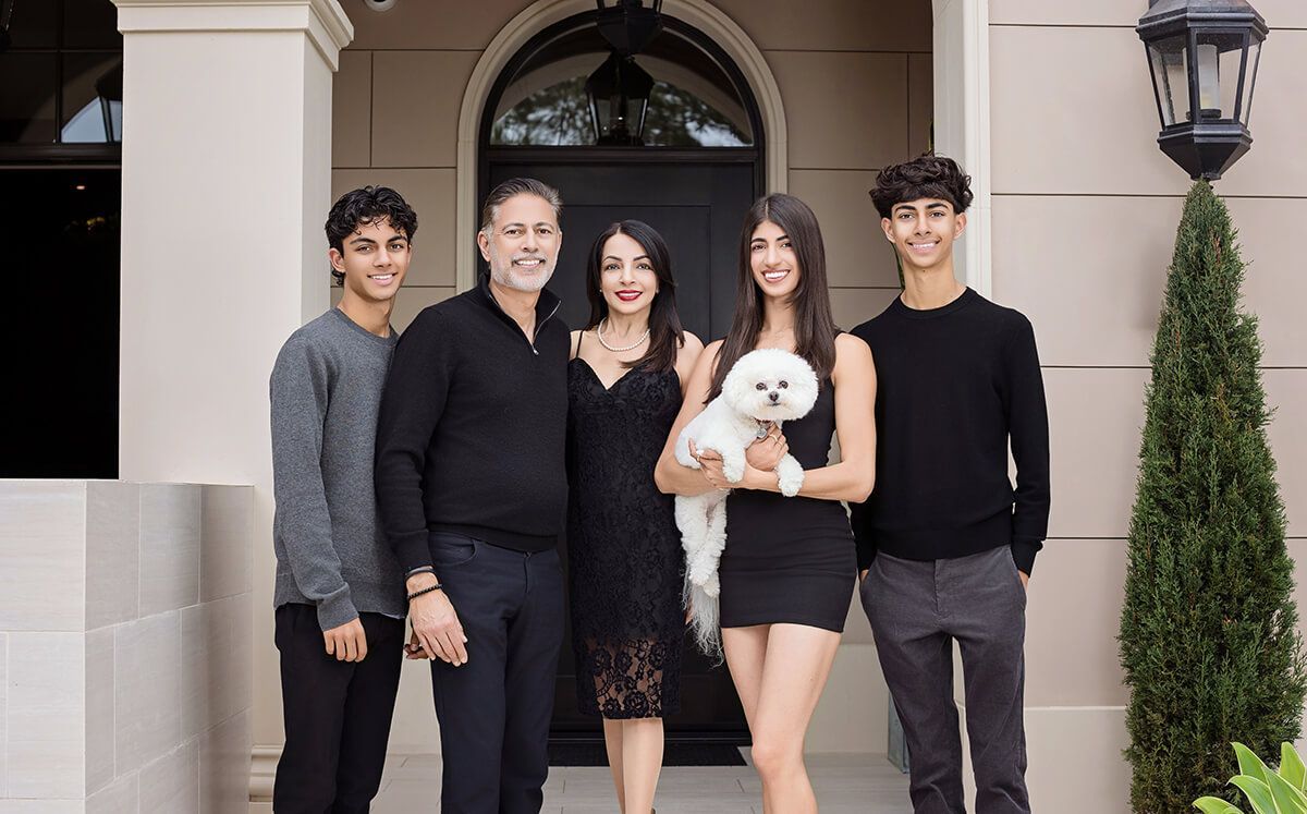 Family portrait session in front of their Newport Beach Home wearing black and grey formal clothing.