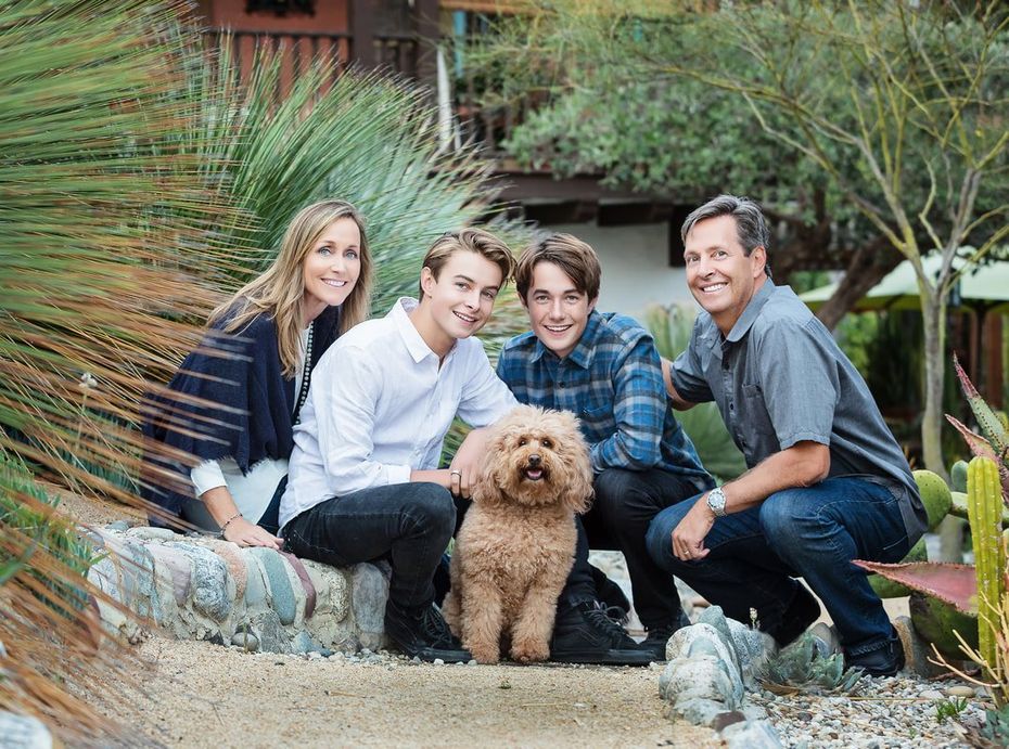 A family is posing for a picture with their dog.