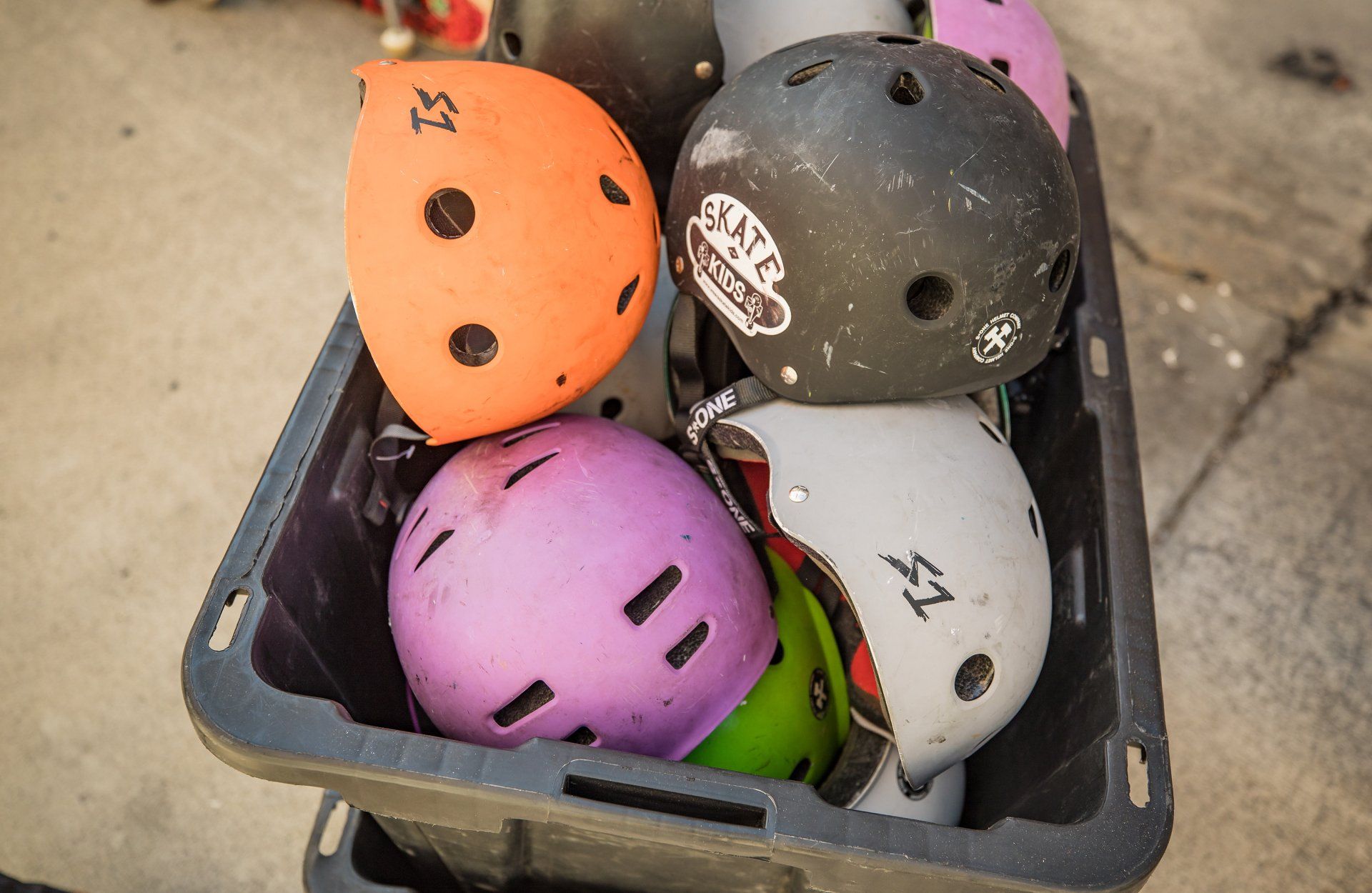 A basket filled with a variety of helmets including one that says safe