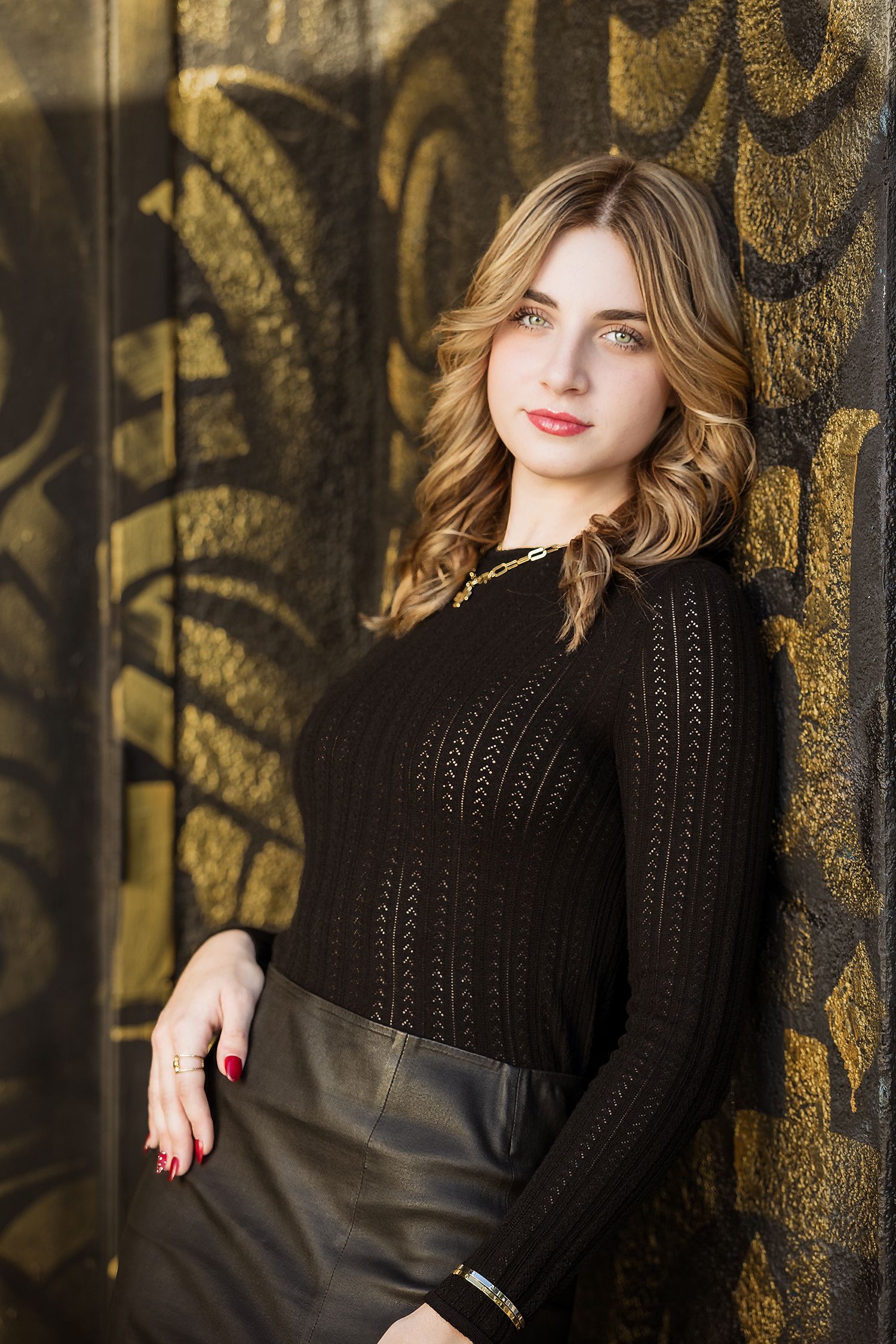 Individual shot of daughter during a family portrait in Santa Ana Art District posing against a wall in a doorway.