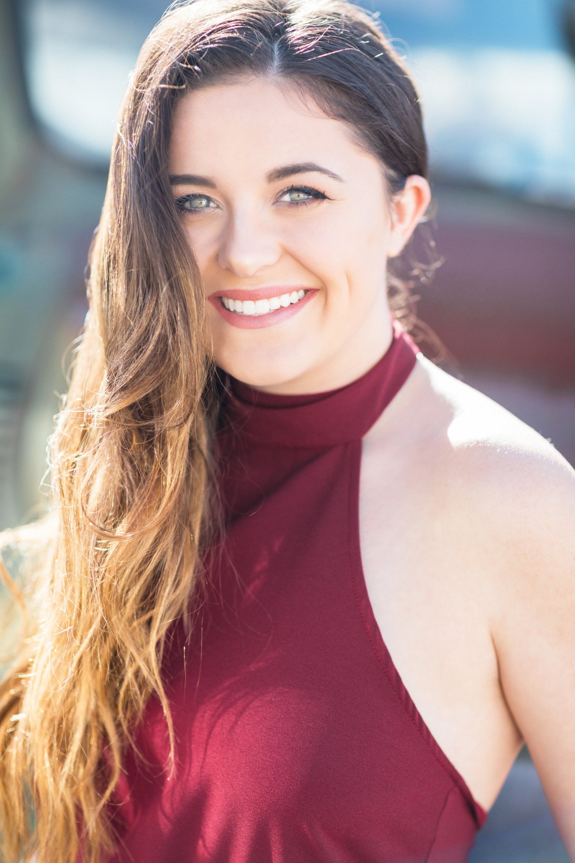 A woman in a red dress is smiling for the camera.