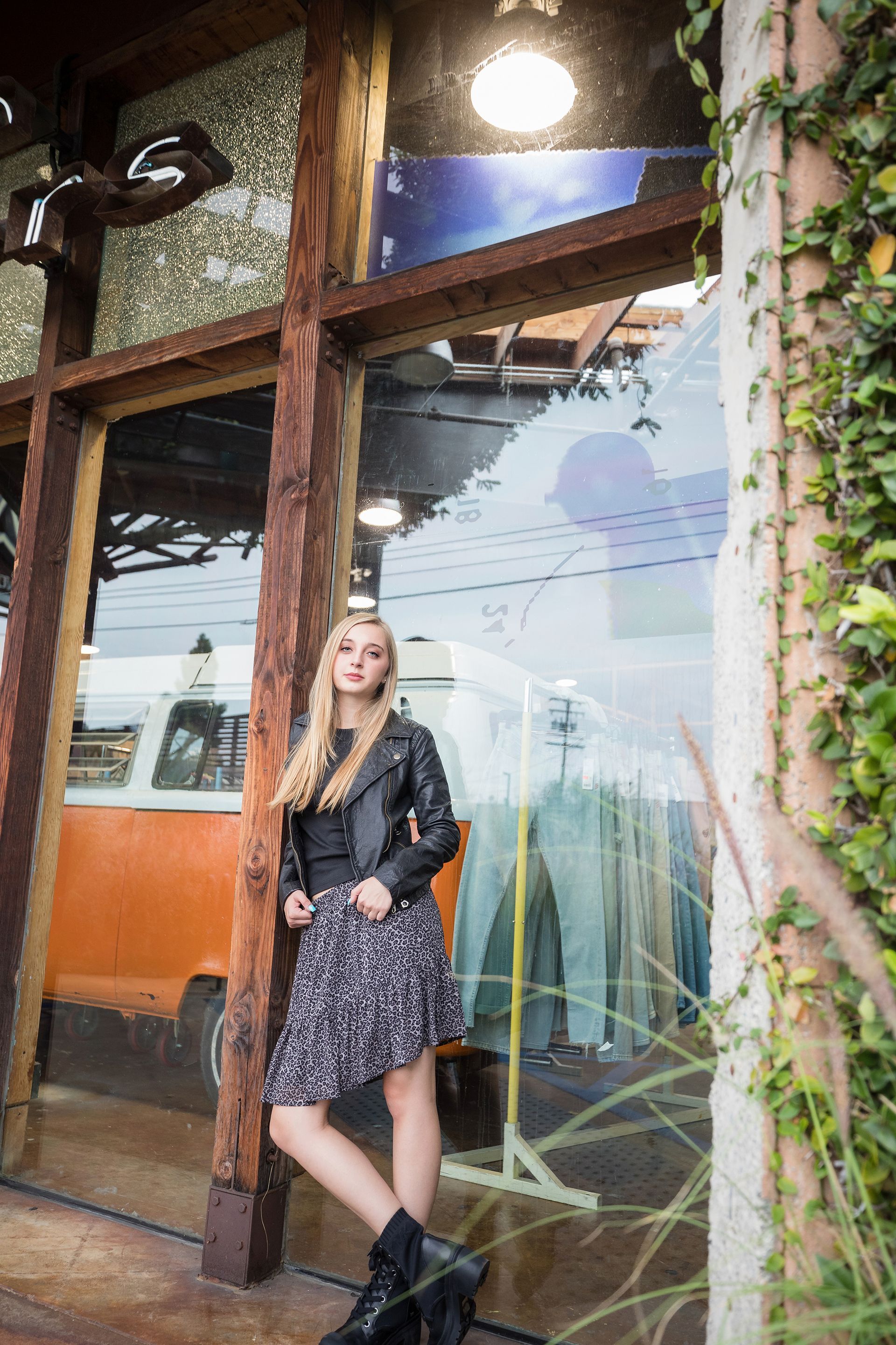A woman is standing in front of a store window.