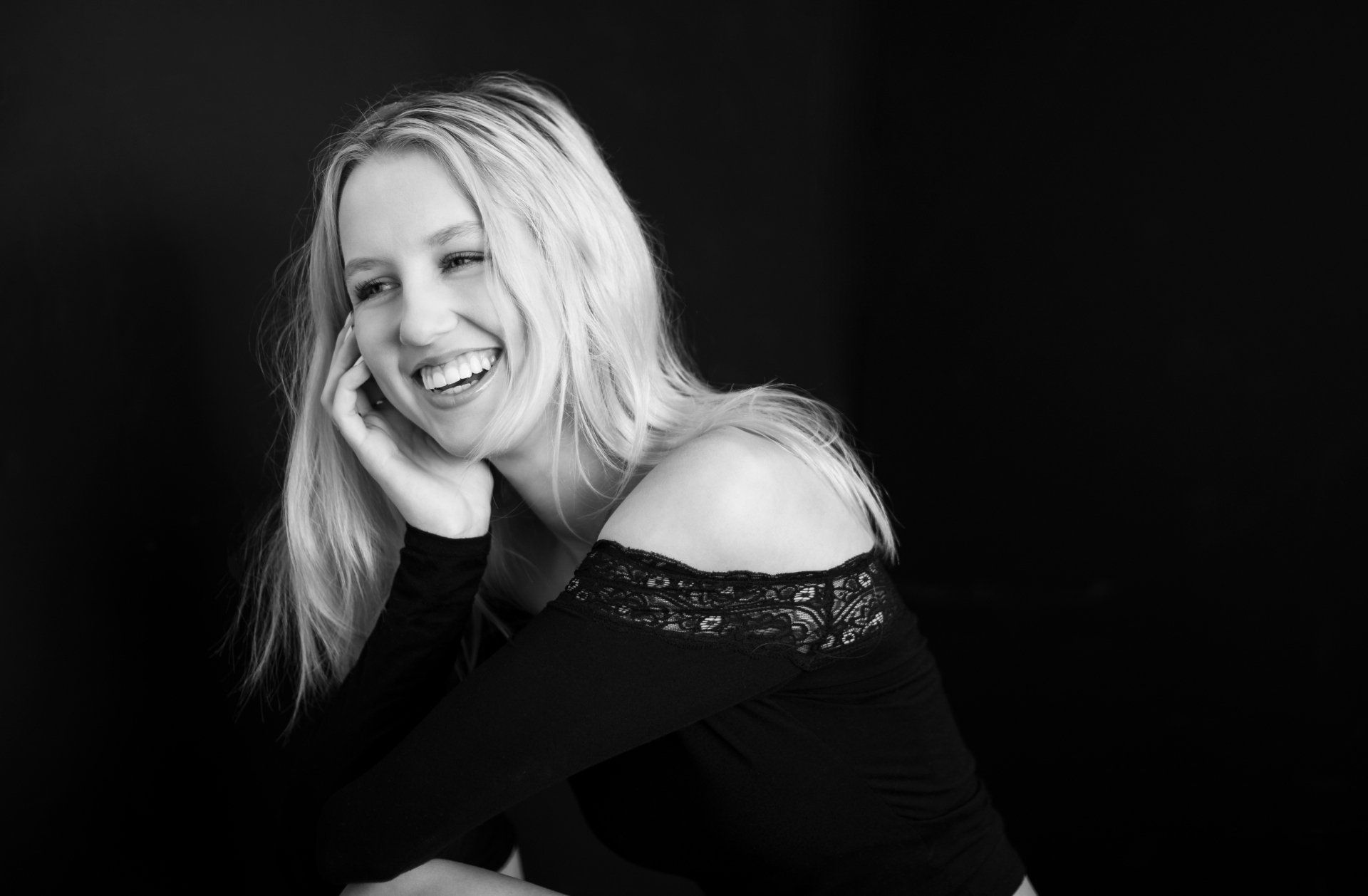 A woman is smiling in a black and white photo.