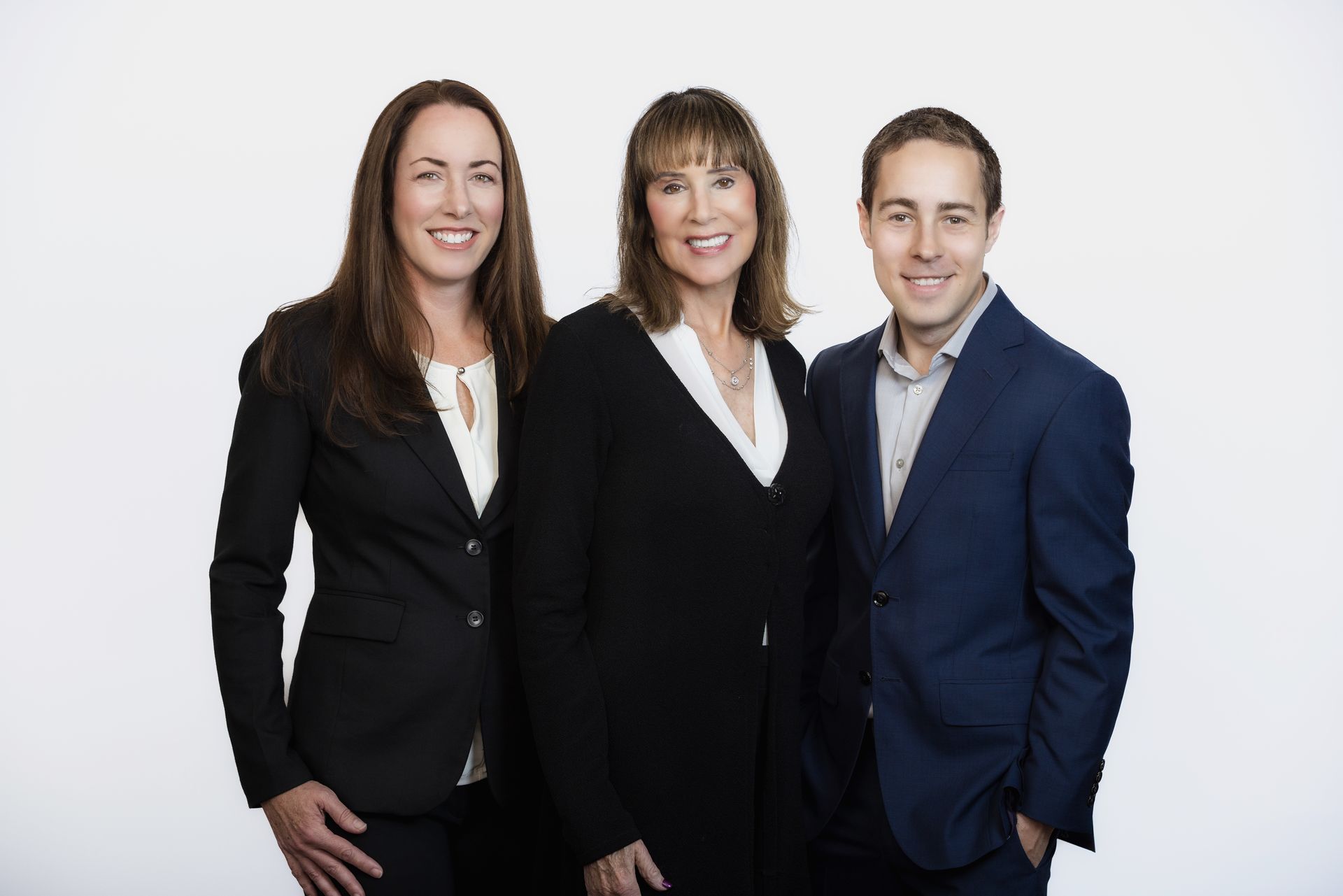 A man and two women are posing for a picture together.