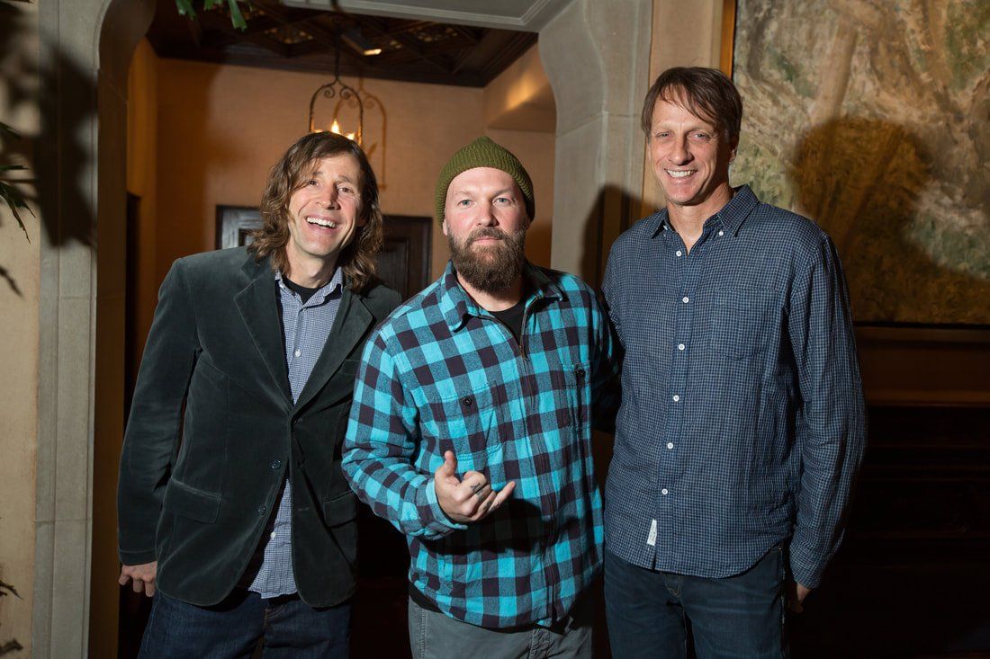 Three men are posing for a picture together in a room.