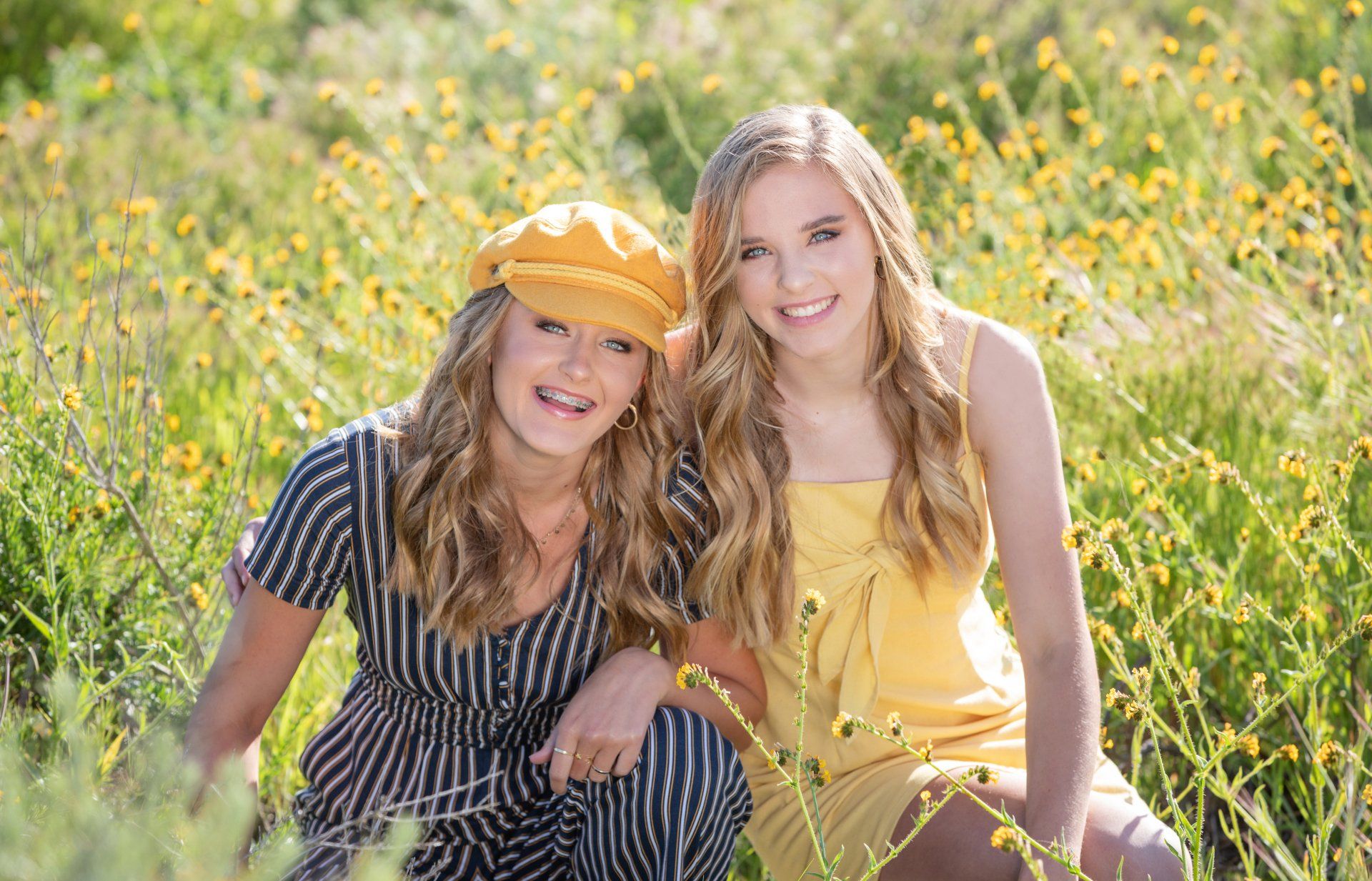 Twin girls posing in the wild flowers in Upper Bay Bay in Newport Beach wearing complimentary colors.