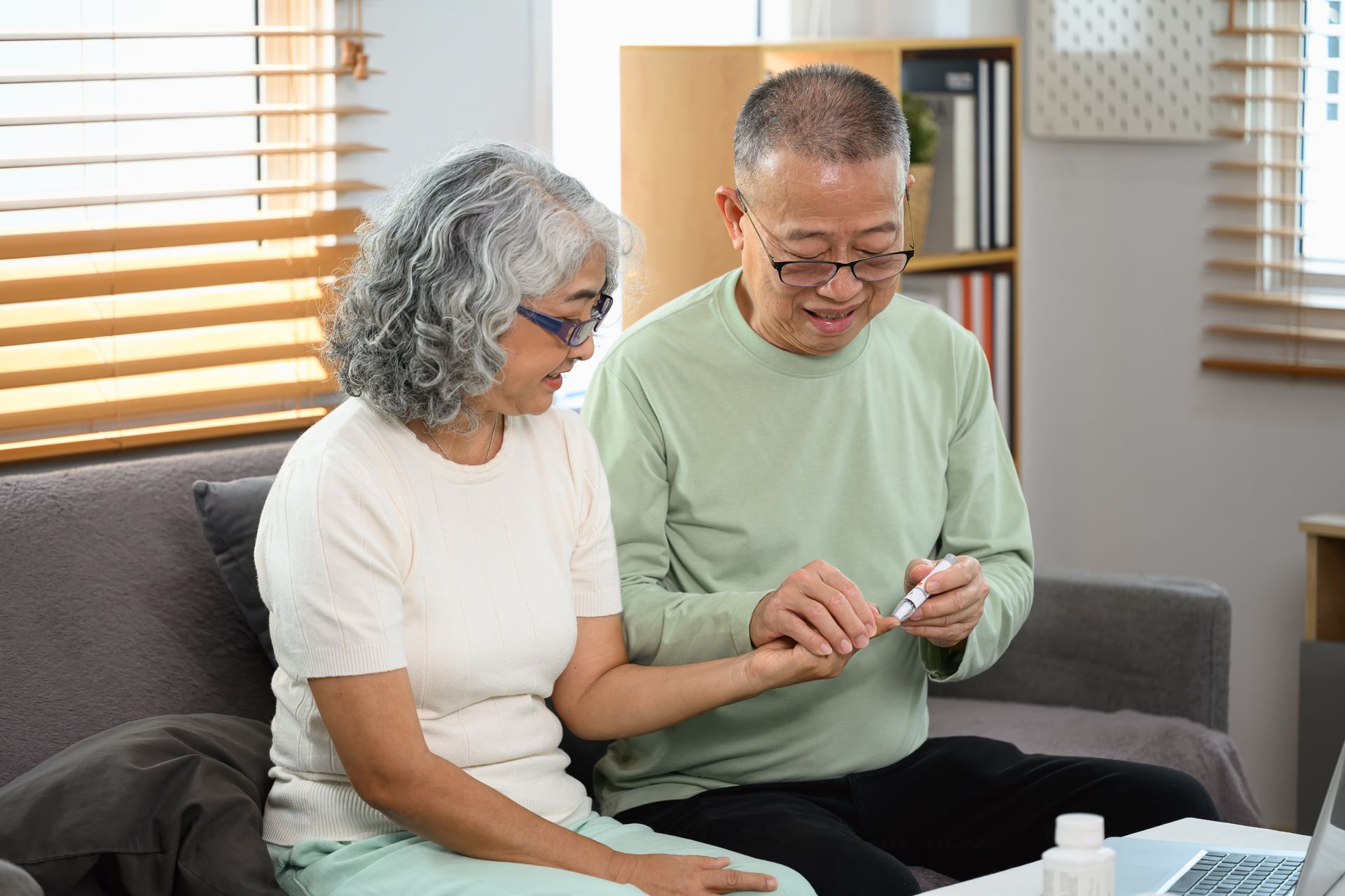 Elderly couple checking blood sugar levels at home.