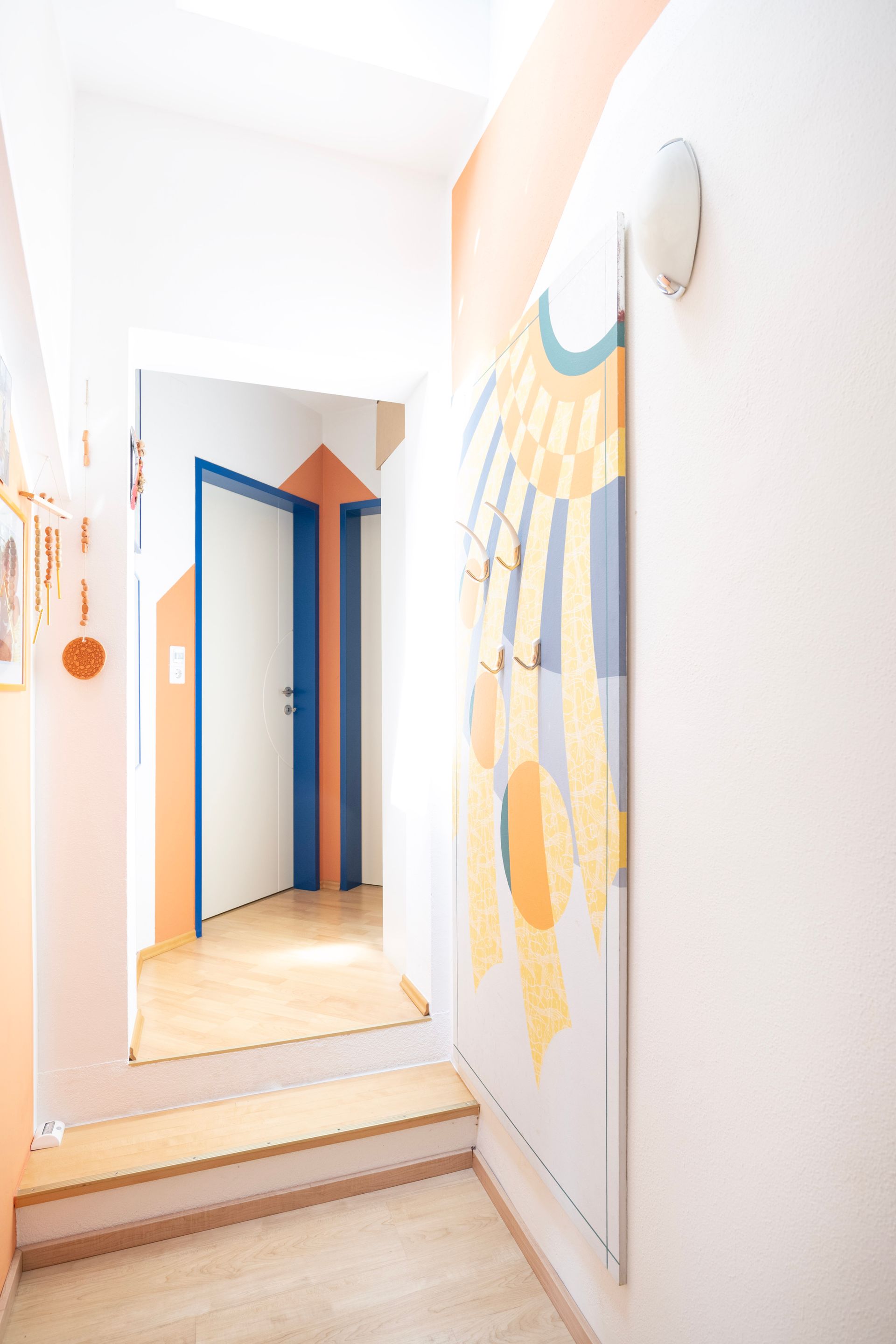 Flur mit einer blauen Tür und einem Gemälde an der Wand