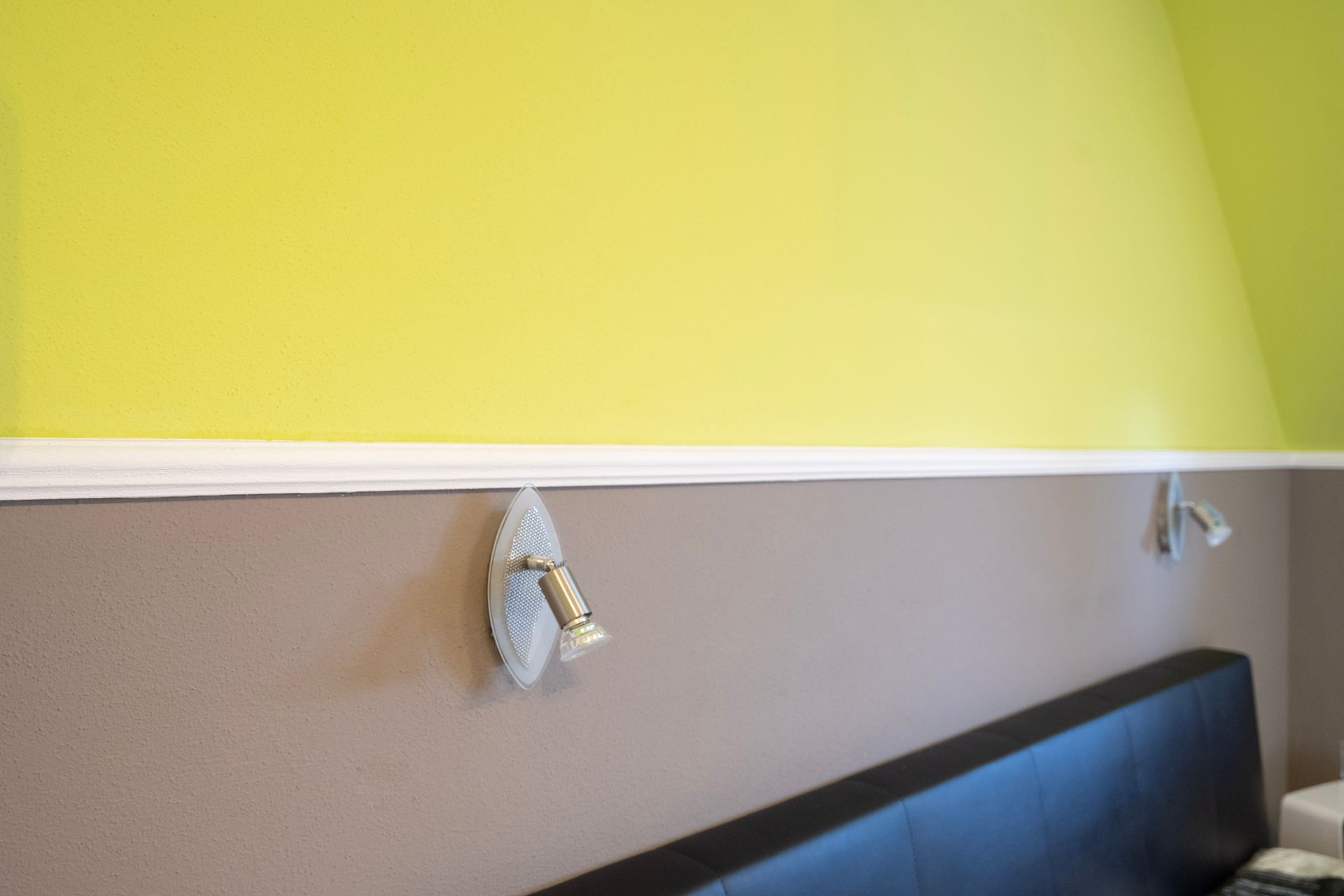 ein Schlafzimmer mit einem Bett und einer gelben Wand