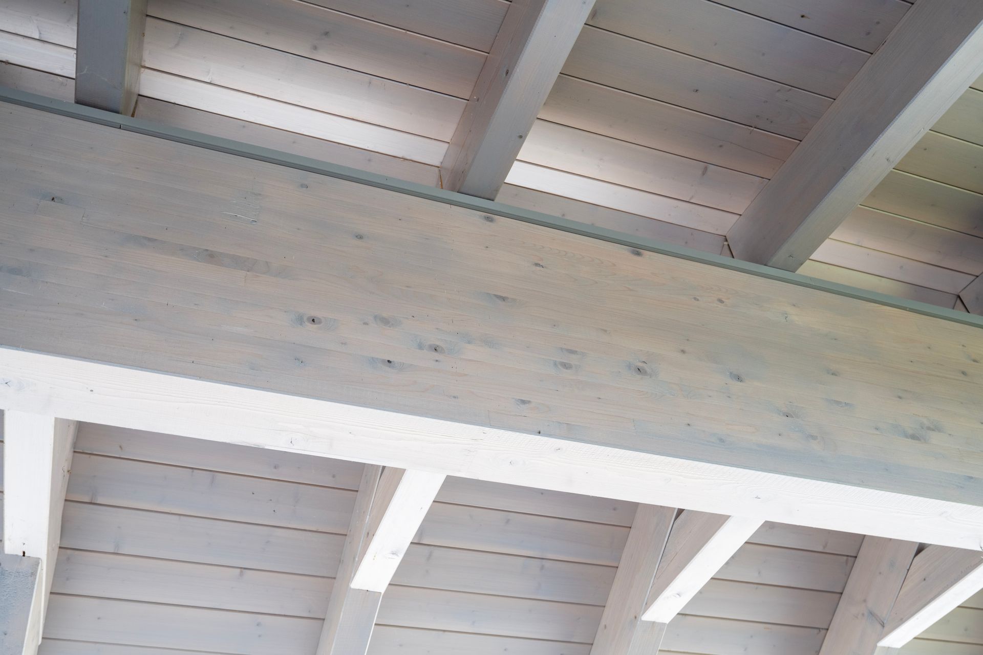 die Decke eines Gebäudes mit weißen Holzbalken