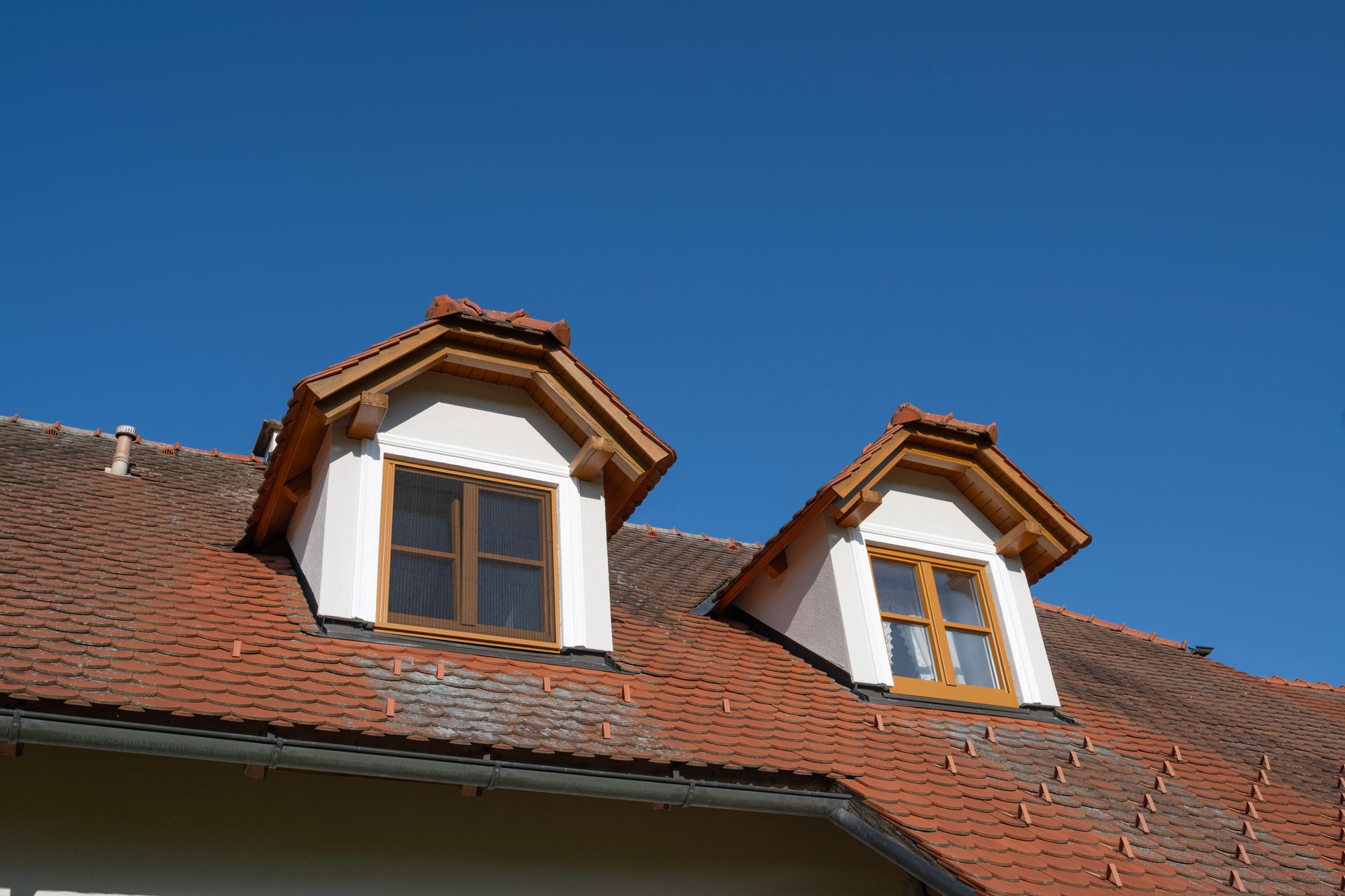 ein Haus mit zwei Fenstern auf dem Dach