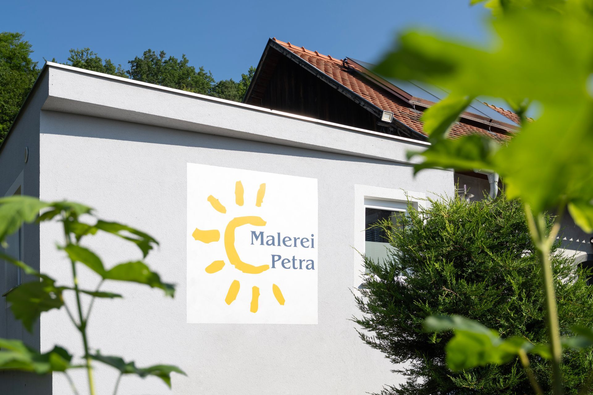 ein weißes Gebäude mit einem gelben Sonnensymbol darauf