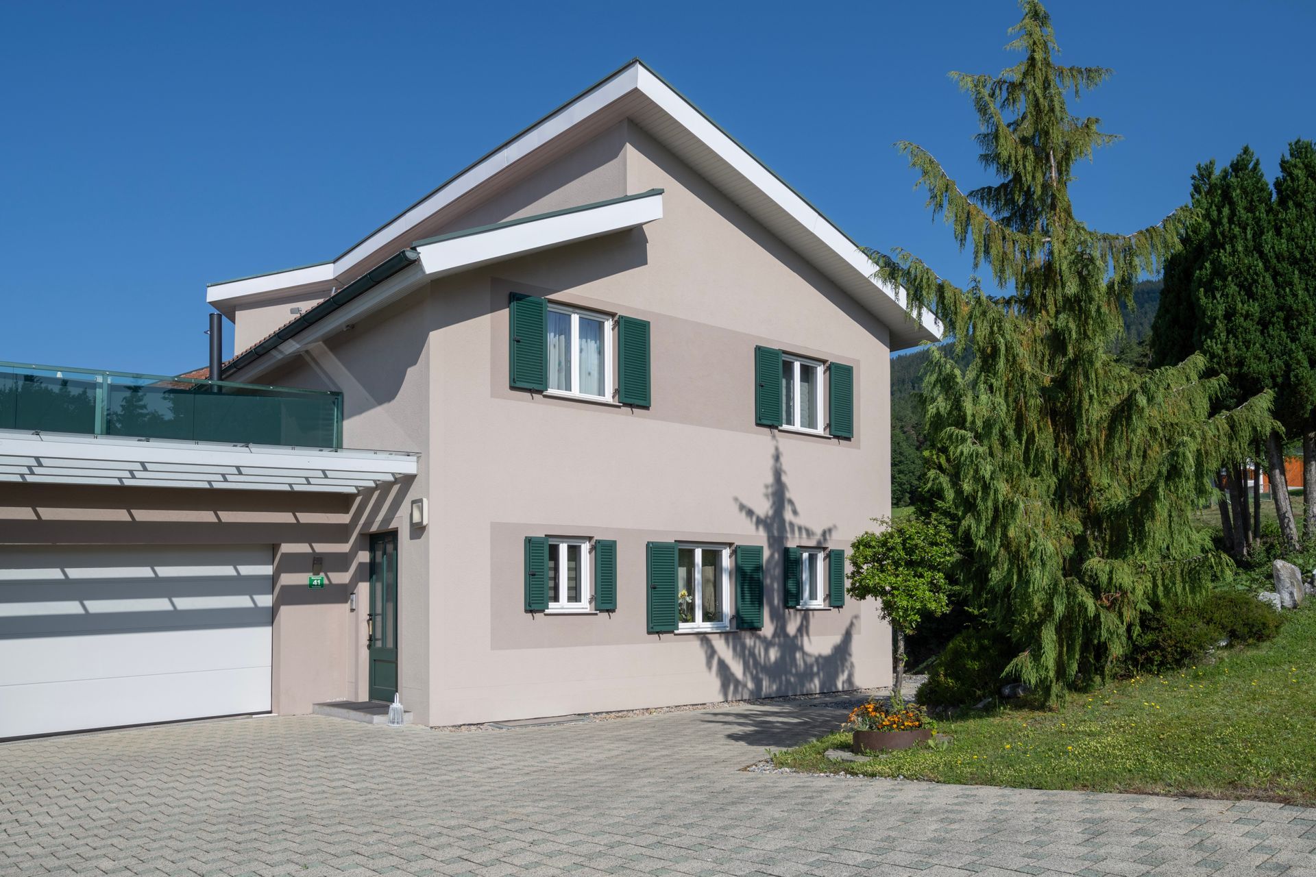 ein Haus mit einer Garage und grünen Fensterläden