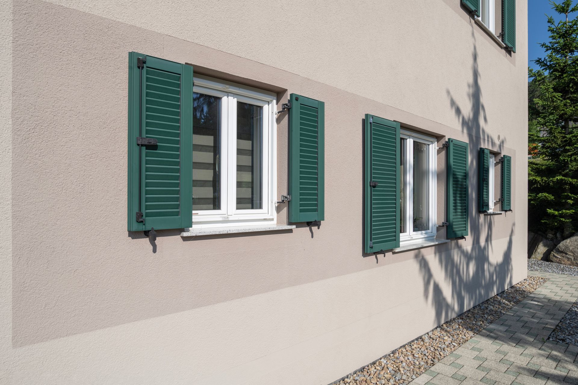 ein Gebäude mit zwei Fenstern und grünen Fensterläden