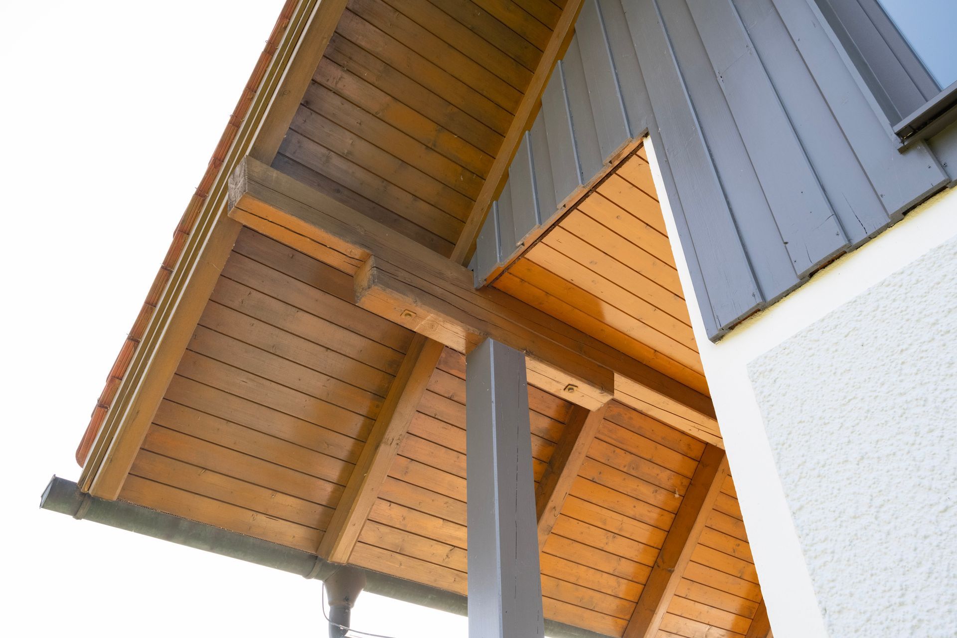 Gebäude mit einem Holzdach und einer grauen Seite