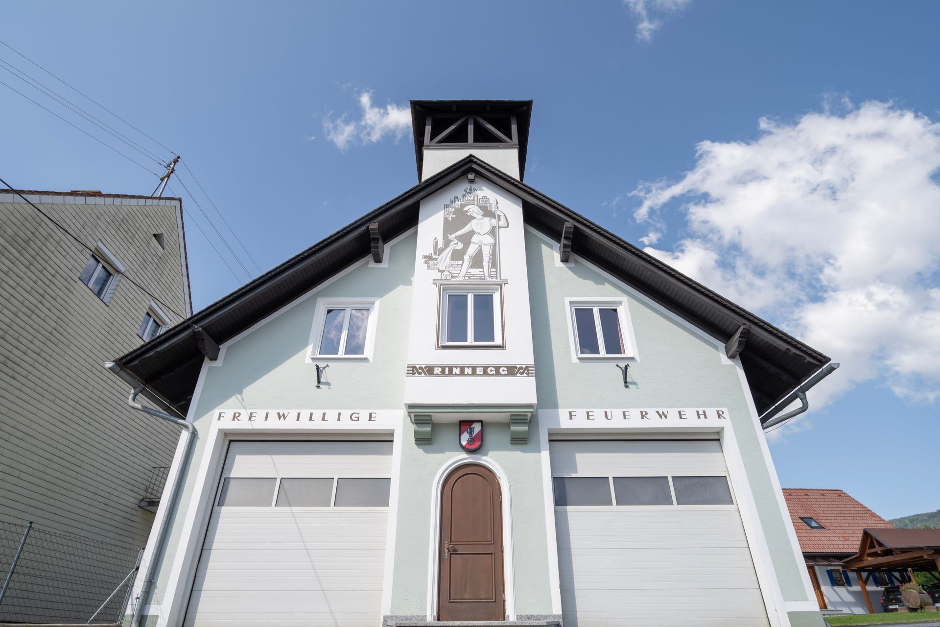 ein großes Gebäude mit einer Tür und zwei Garagen