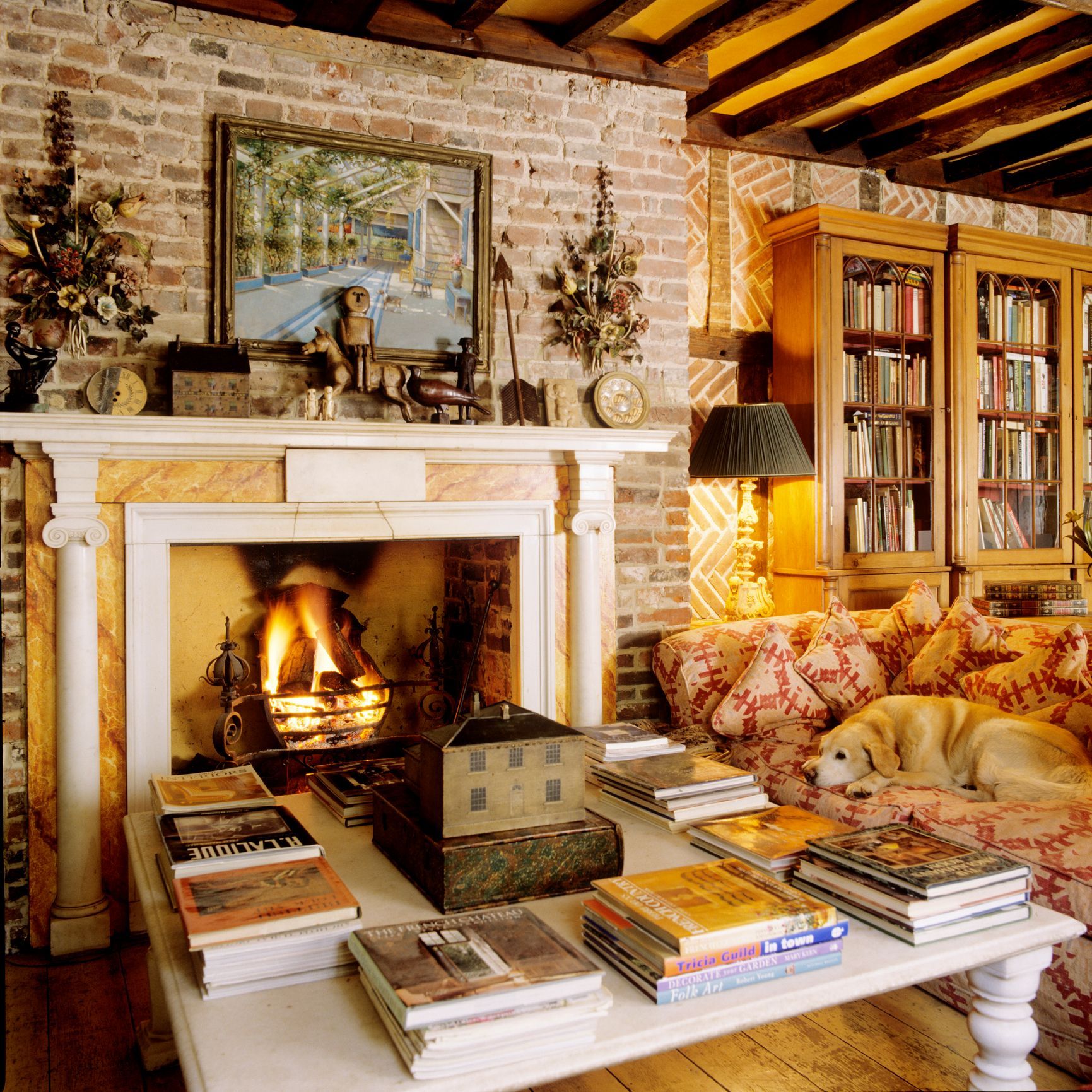 A living room with a fireplace and a table with books on it