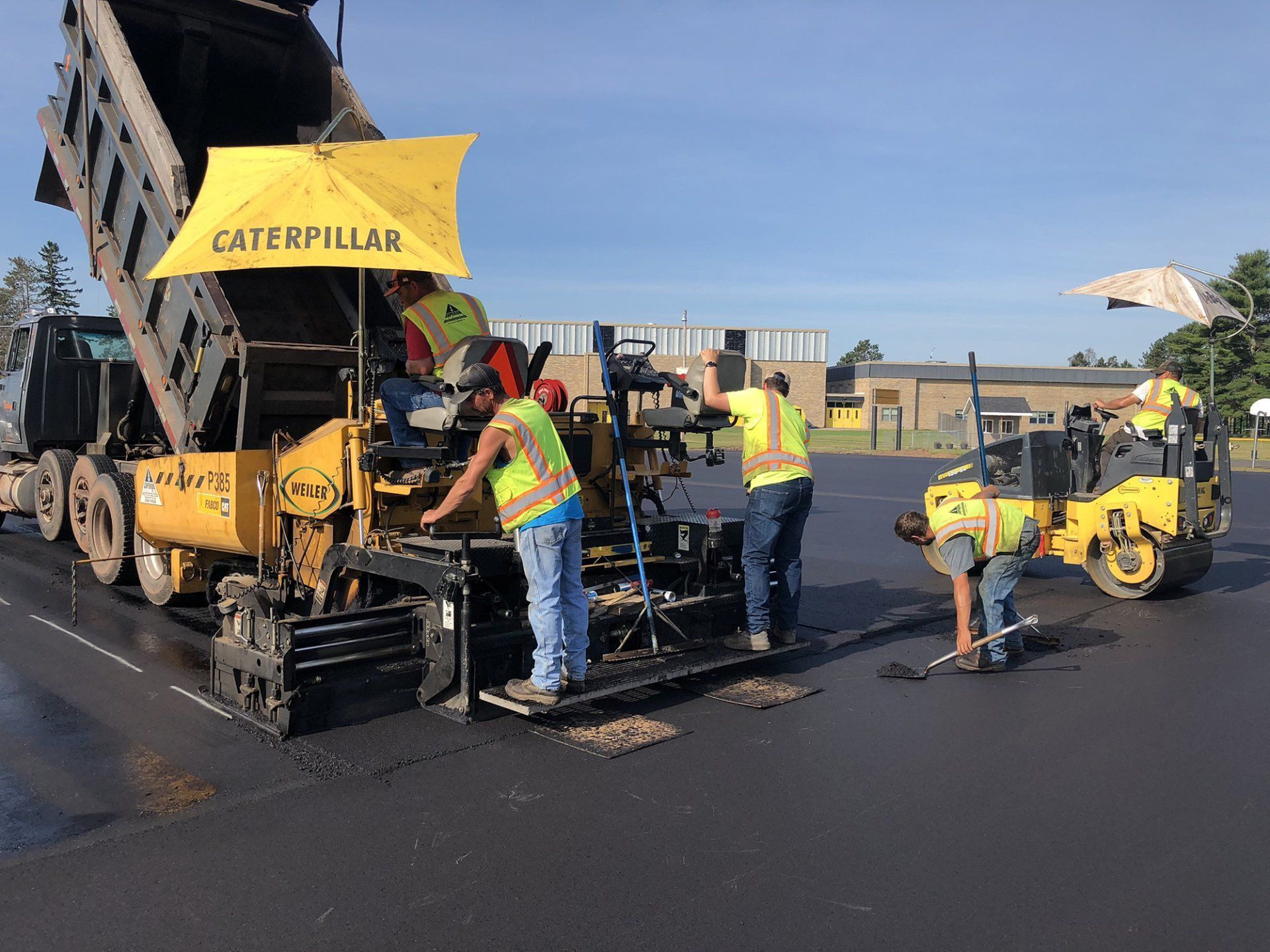 A group of construction workers are working on a road.