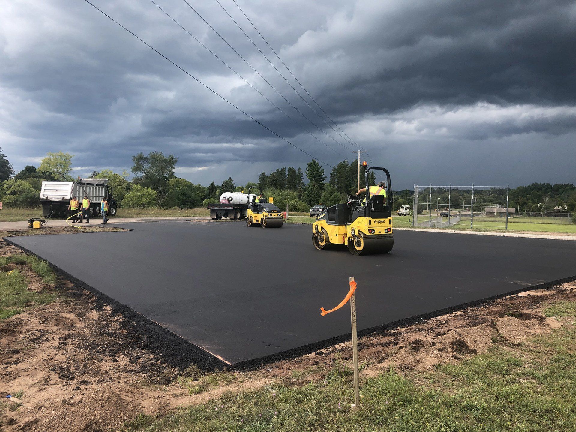 A group of construction vehicles are working on a road.