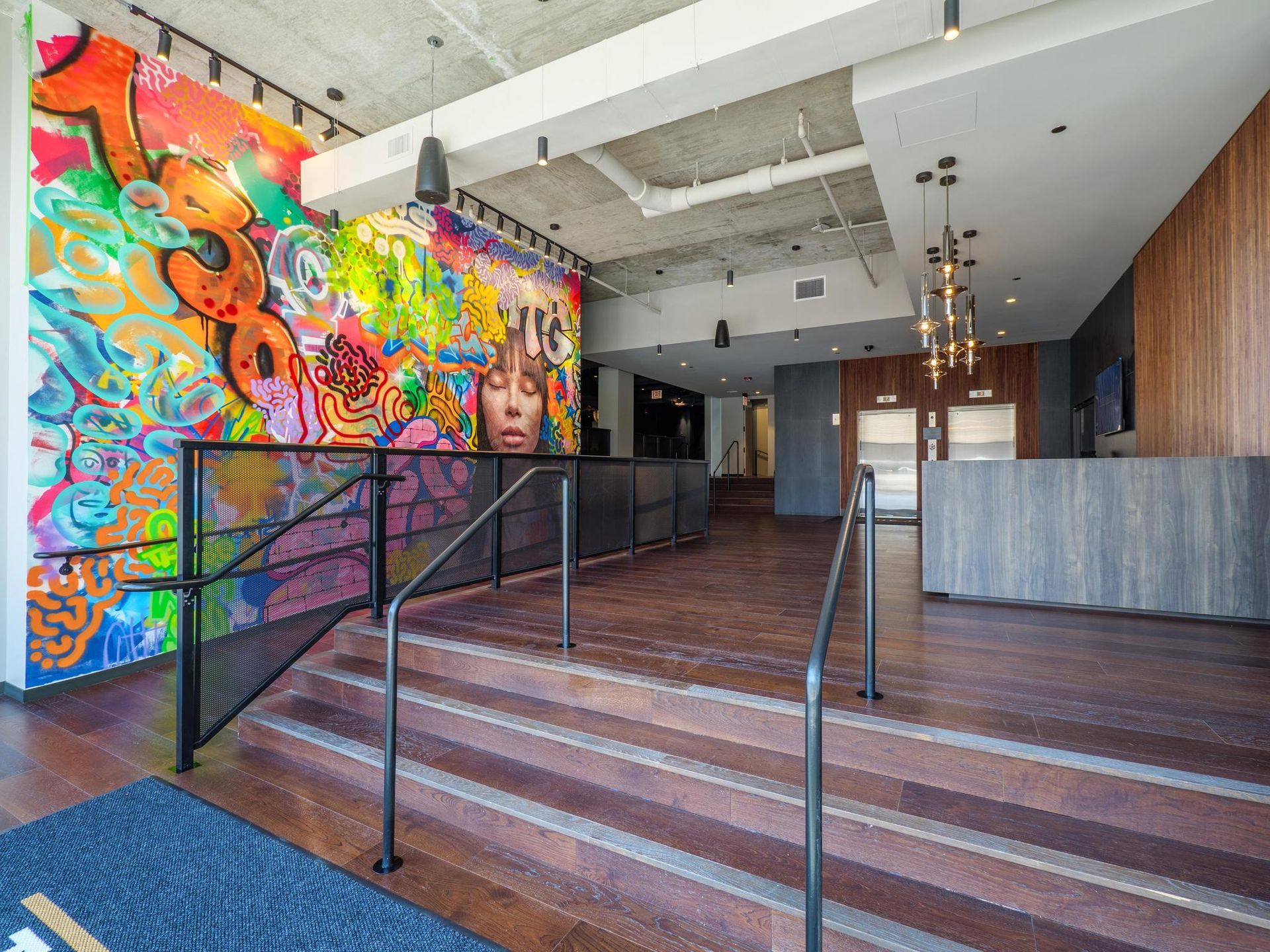 The Thompson at Fulton Market Apartments lobby featuring a colorful mural and steps leading to the elevators