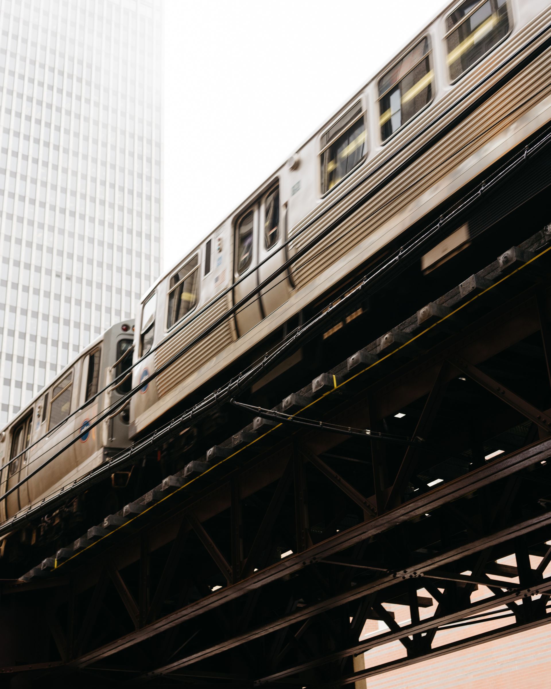 A subway train is going over a bridge in a city